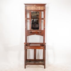 Shapland & Petter. An Arts & Crafts walnut hall stand with a copper panel