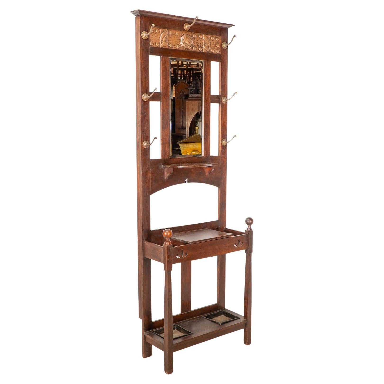 Shapland & Petter. An Arts & Crafts walnut hall stand with a copper panel