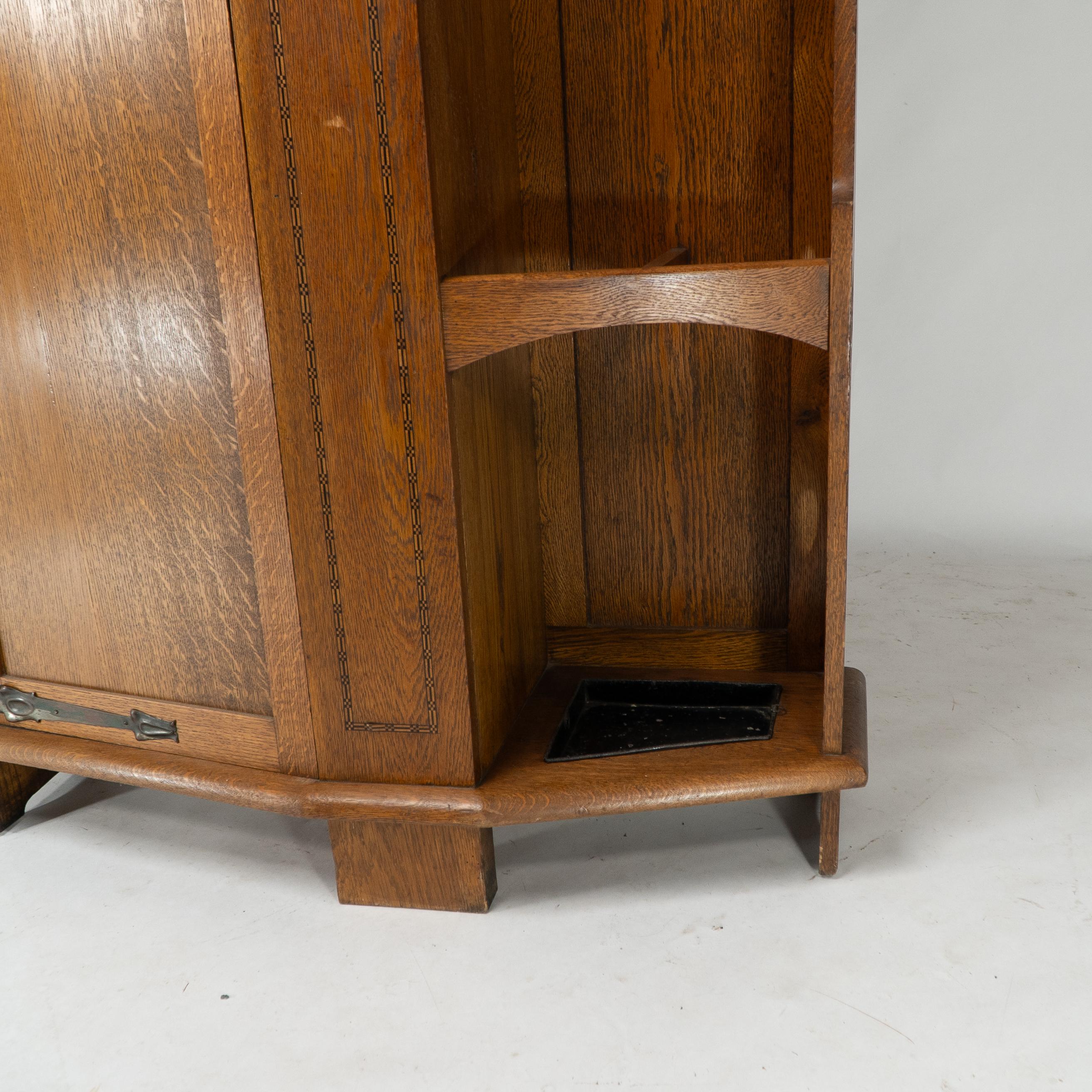 Shapland & Petter attri. An Arts & Crafts oak hall cupboard with flaring cornice For Sale 7