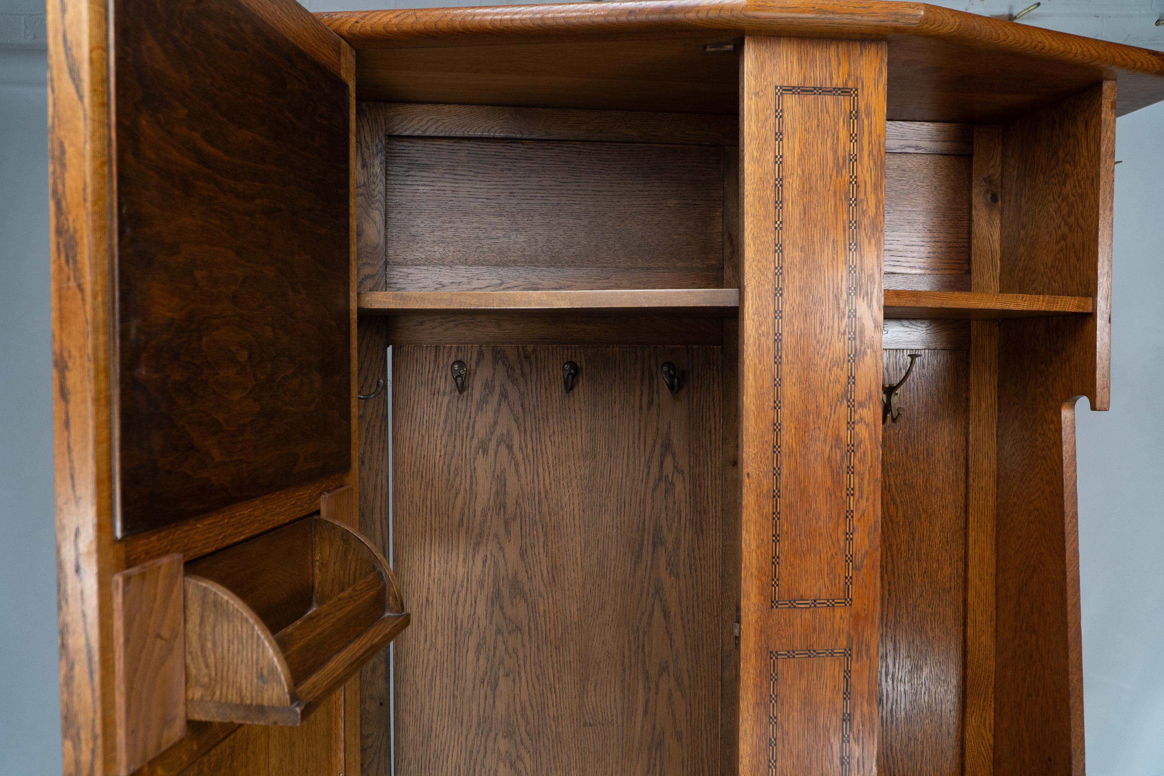 Shapland & Petter attri. An Arts & Crafts oak hall cupboard with flaring cornice For Sale 9