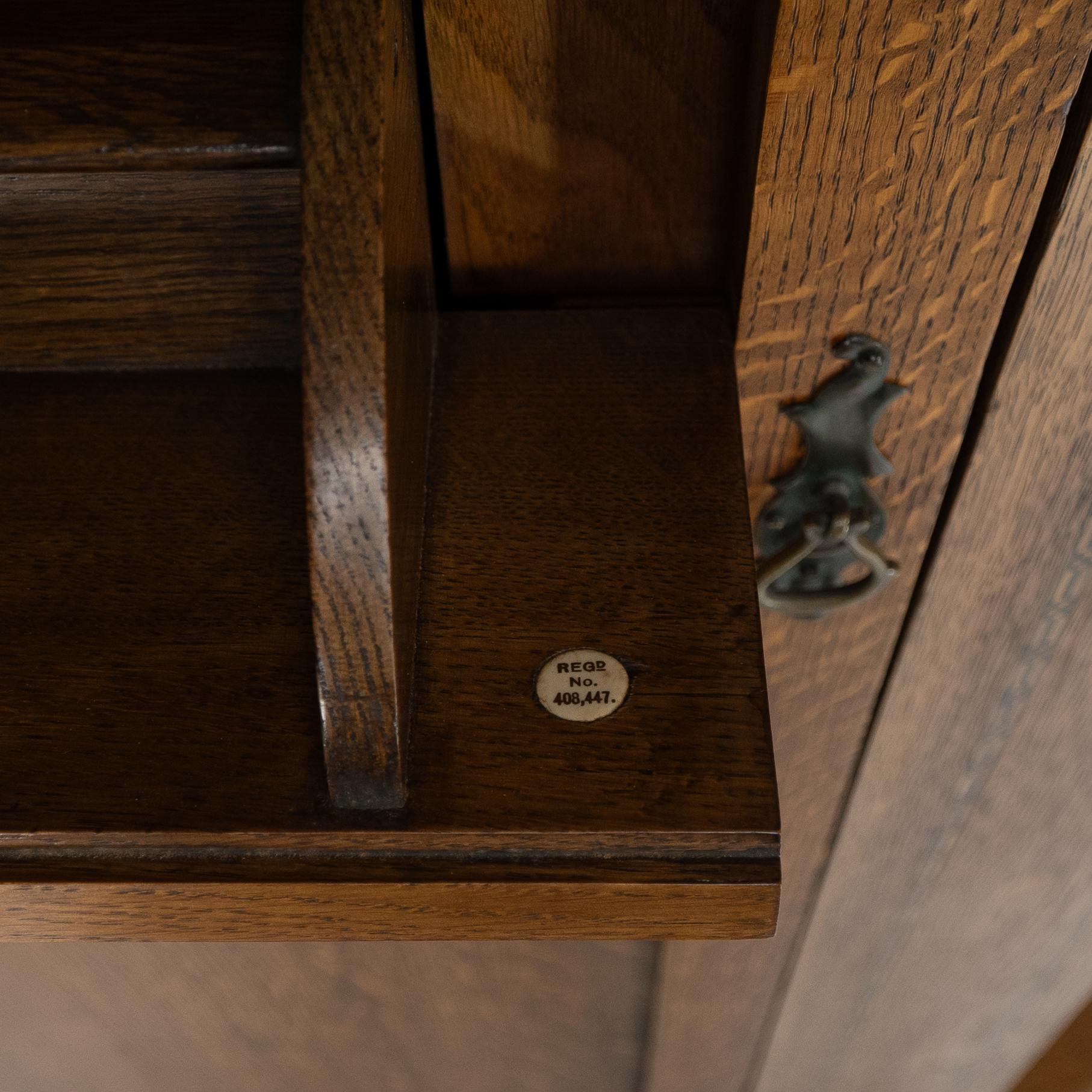 Shapland & Petter attri. An Arts & Crafts oak hall cupboard with flaring cornice For Sale 10