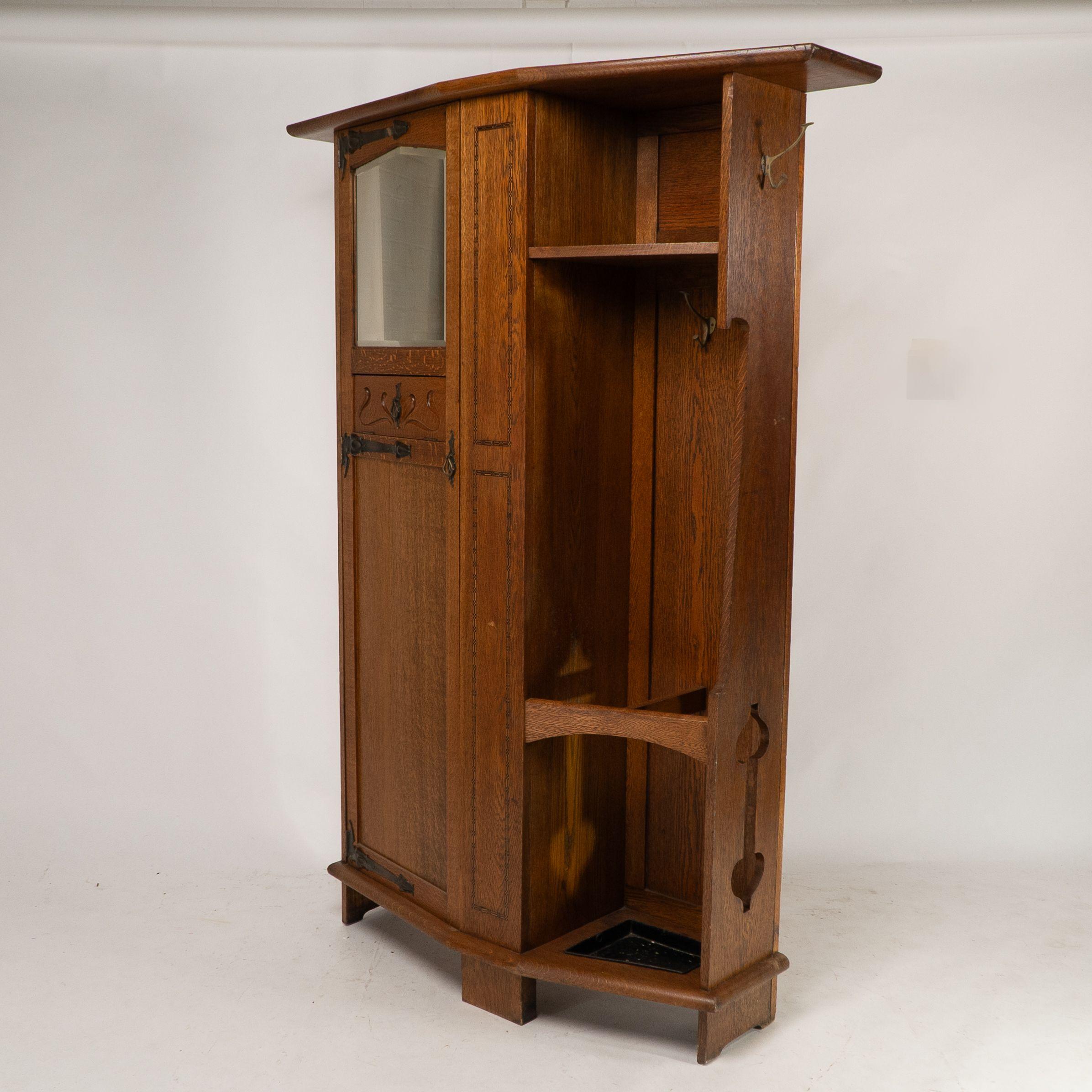 Arts and Crafts Shapland & Petter attri. An Arts & Crafts oak hall cupboard with flaring cornice For Sale