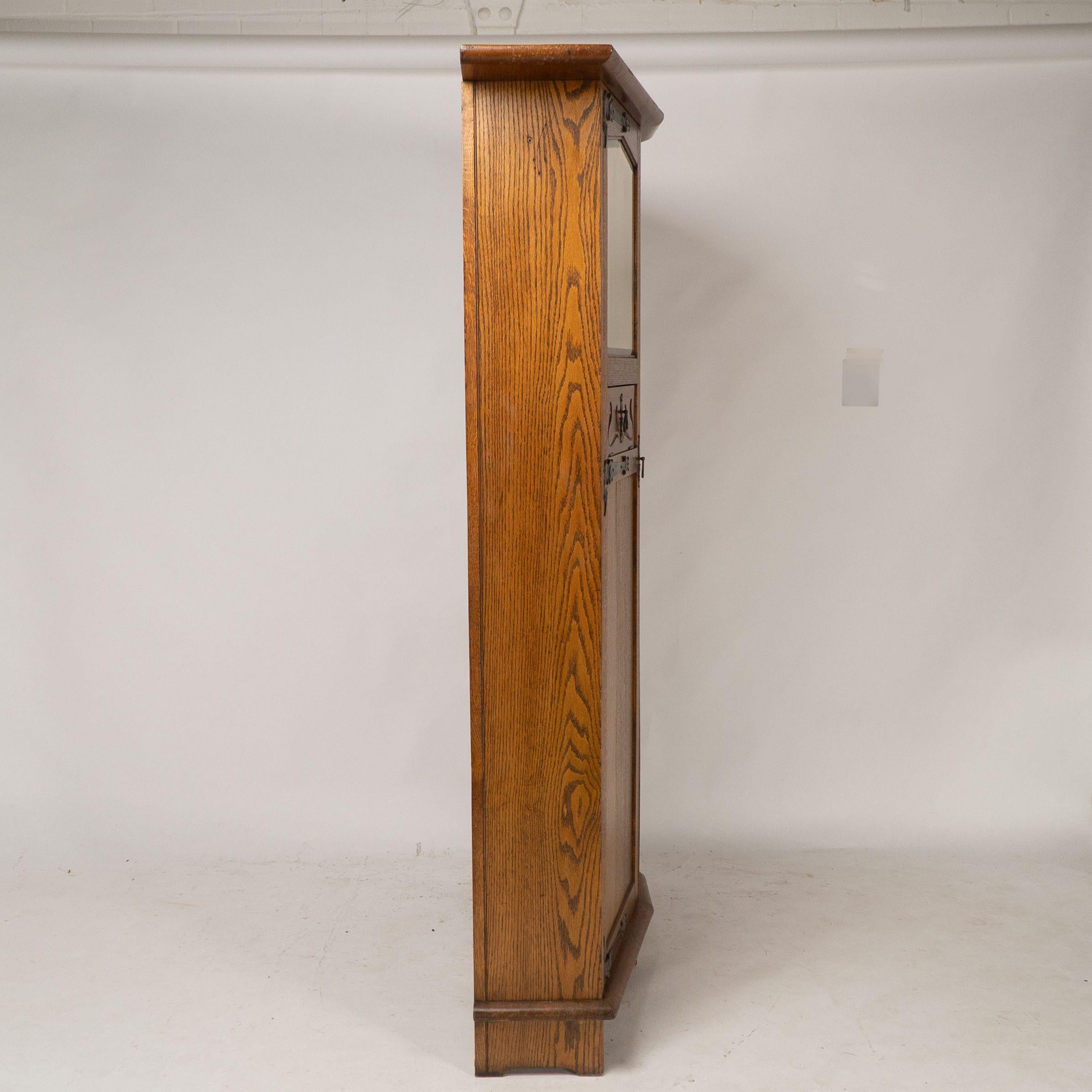Shapland & Petter attri. An Arts & Crafts oak hall cupboard with flaring cornice In Good Condition For Sale In London, GB