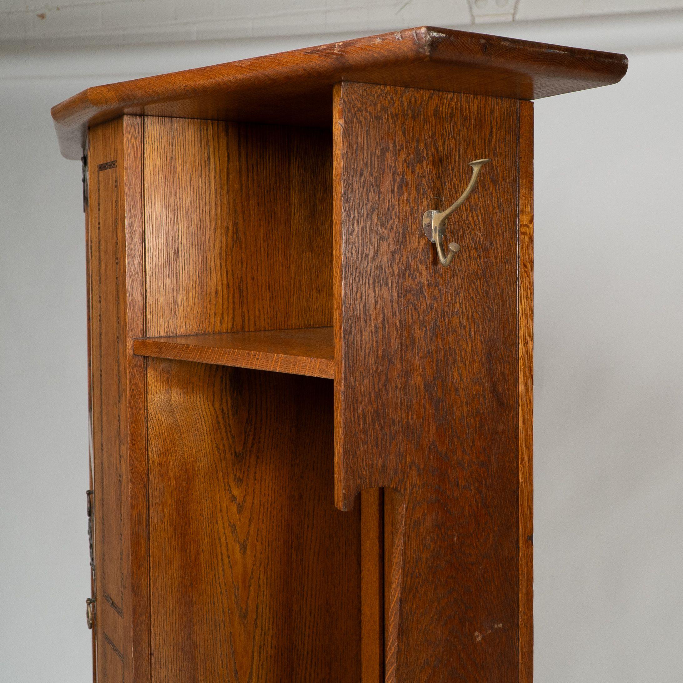 Shapland & Petter attri. An Arts & Crafts oak hall cupboard with flaring cornice For Sale 1
