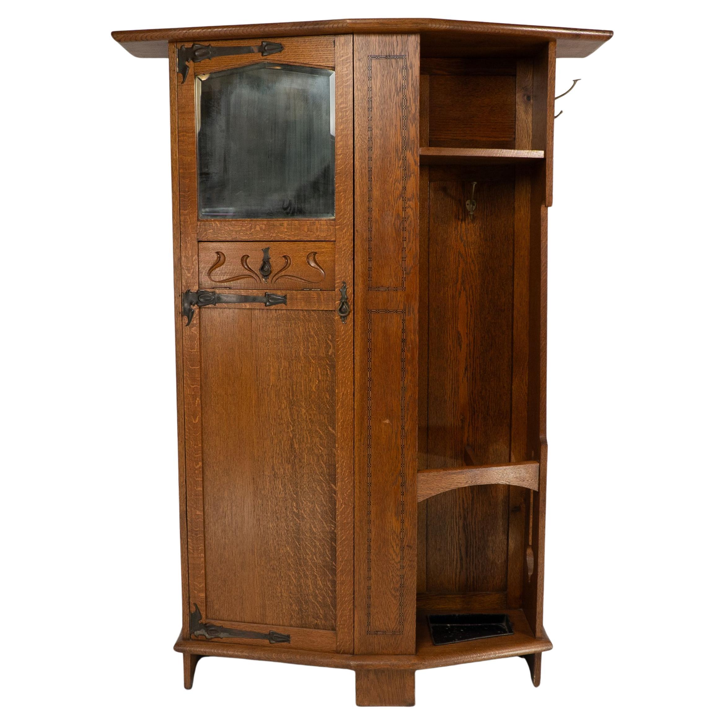 Shapland & Petter attri. An Arts & Crafts oak hall cupboard with flaring cornice
