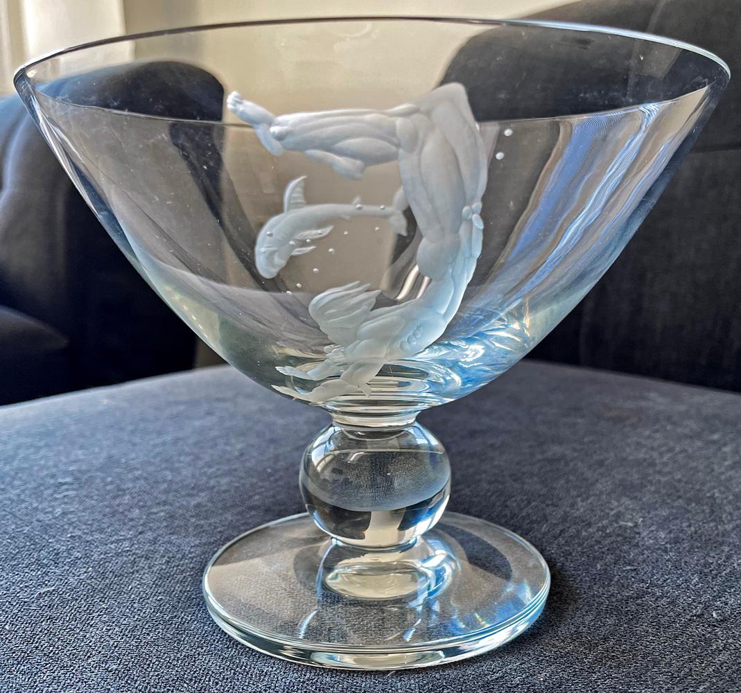 Clearly inspired by the renowned series of engraved glass pieces by Vicke Lindstrand for Orrefors in the 1930s -- which depicted one, two or three nude male divers, some of them shown hunting for sharks -- this high stye Art Deco bowl features a