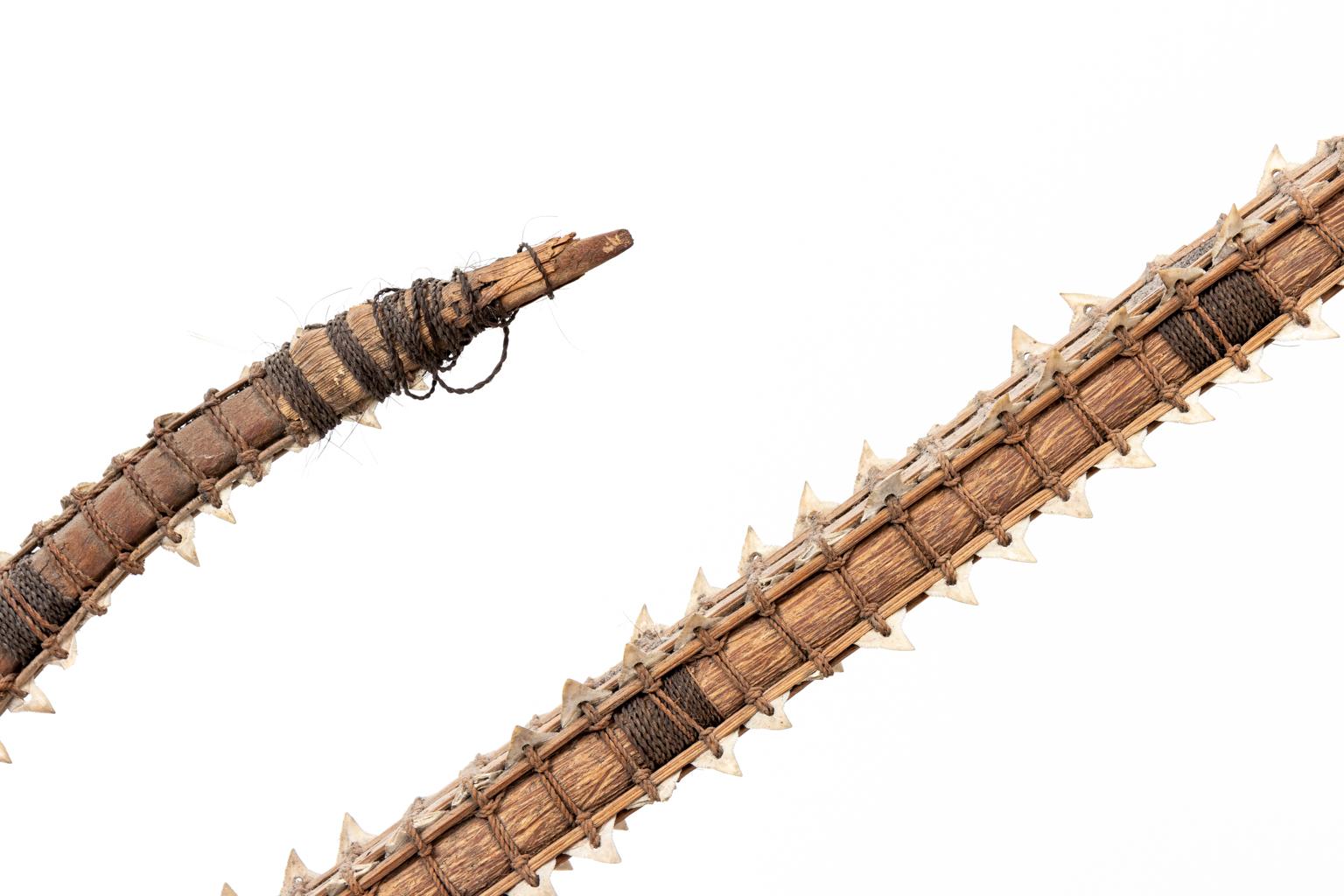 Circa 19th century or earlier shark teeth edged sword from the Gilbert Islands. The Islands were so scarce on resources surrounded by shark populated waters that swords were made by mounting shark's teeth on palm wedge strips and bound with cords of