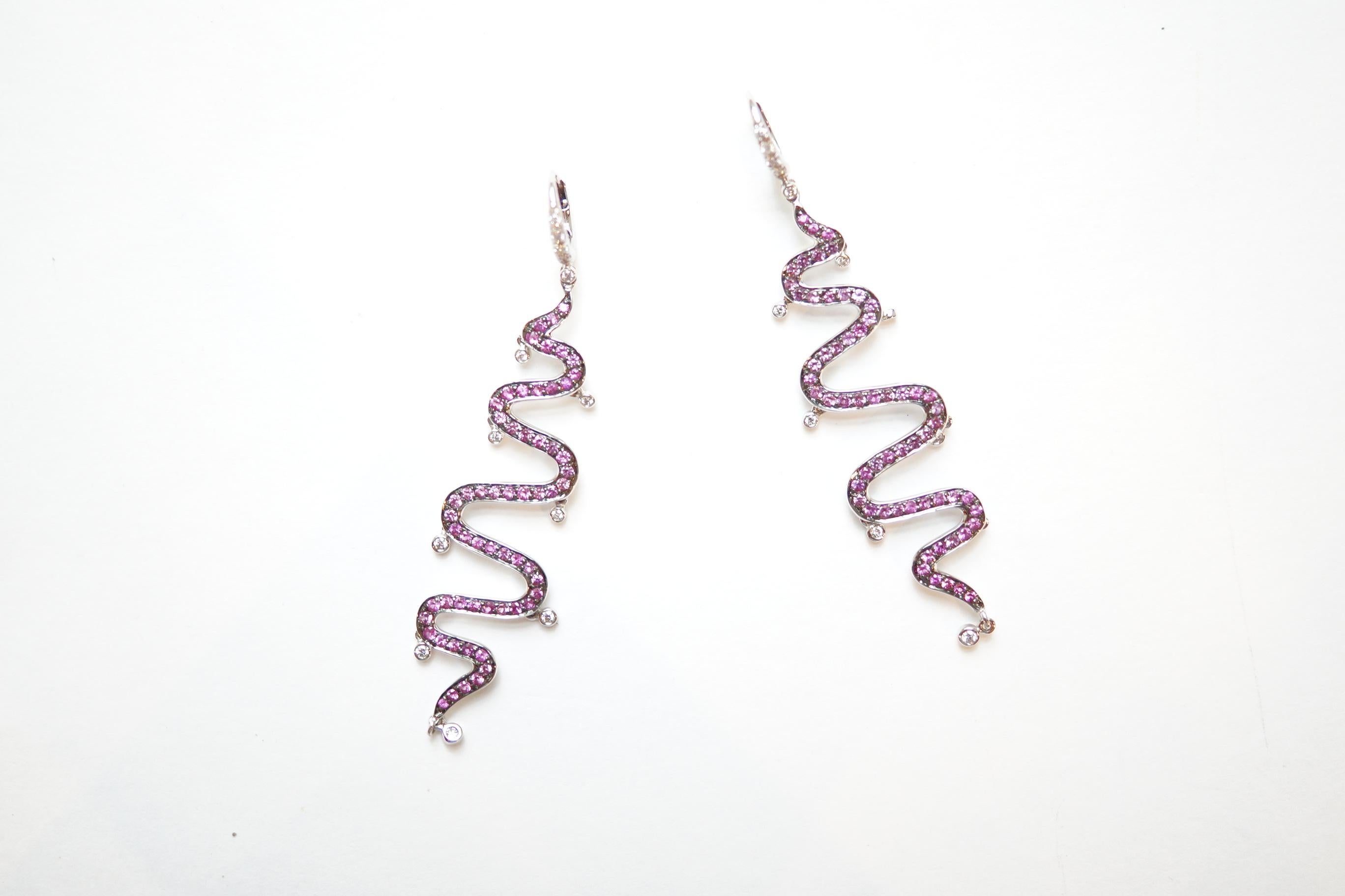 Shimmee® Swirl Earrings
A pair of eighteen-karat white gold earrings in a delicate undulating design.  Each earring consists of a line of pink sapphires that snakes downwards from a white diamond earwire, adorned at each of the eight curvatures with
