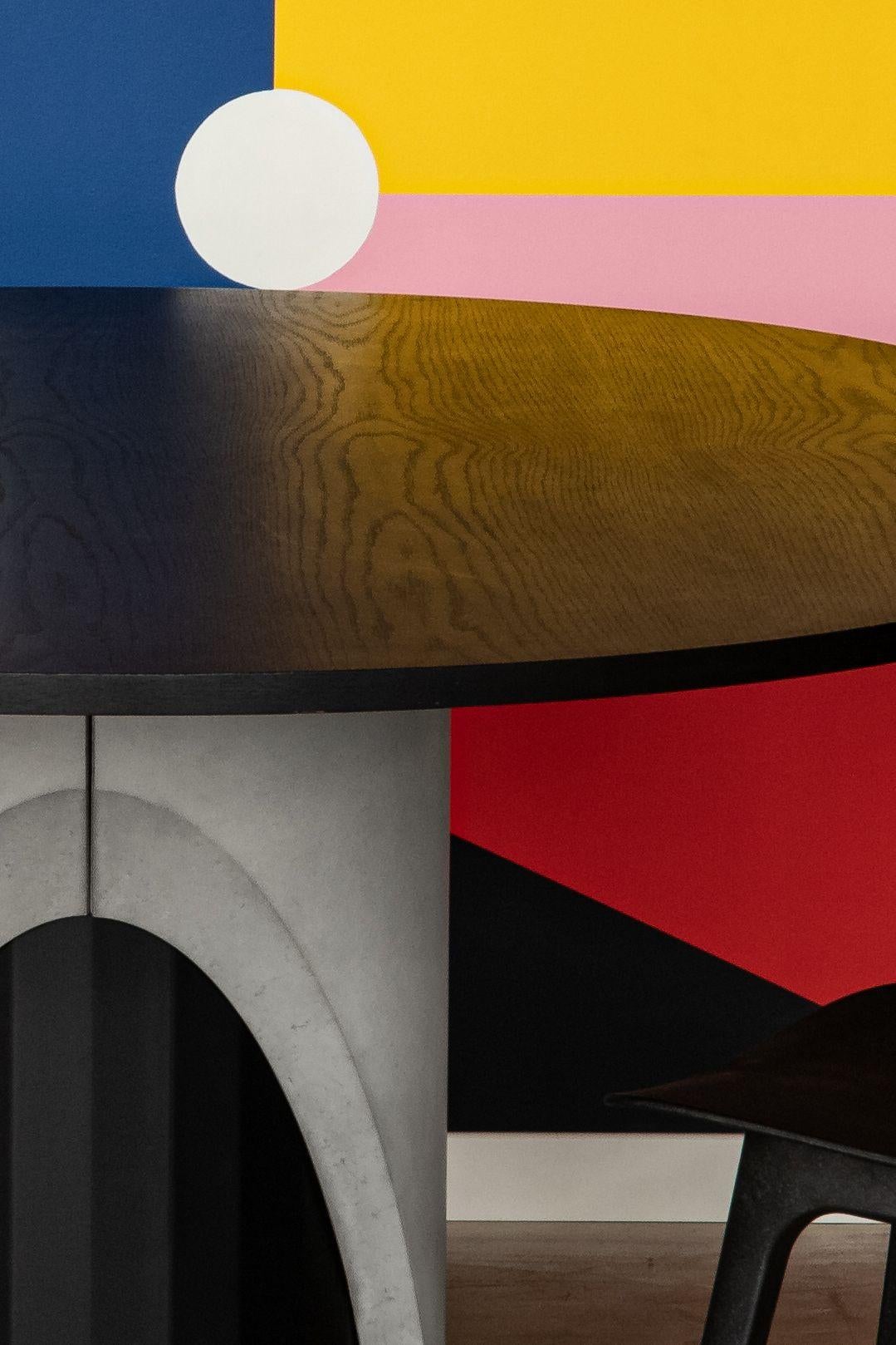 With the Sharp dining table, designer Bertrand Jayr destructures the symbiosis between concrete and metal. The reversible concrete ballast protects and reveals a black metal shaft with delicate facets. The oak veneer top is tinted with a deep matte