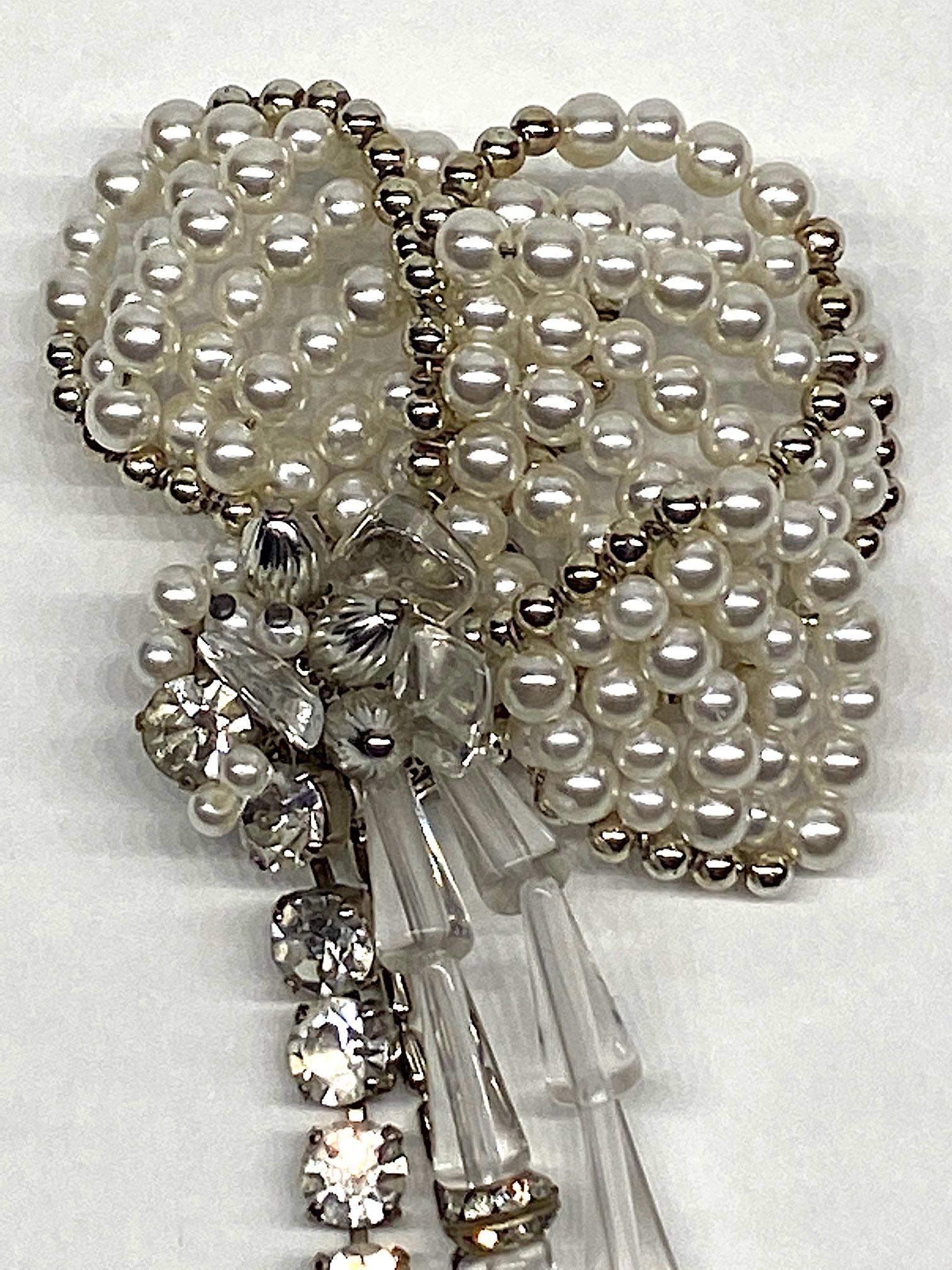A truly stunning and large three dimensional flower brooch by fashion jewelry designer Sharra Pagano of Milan, Italy. The petals of the flower are hand strung faux pearls and rhodium plate silver beads that over lap each other. They are attached to