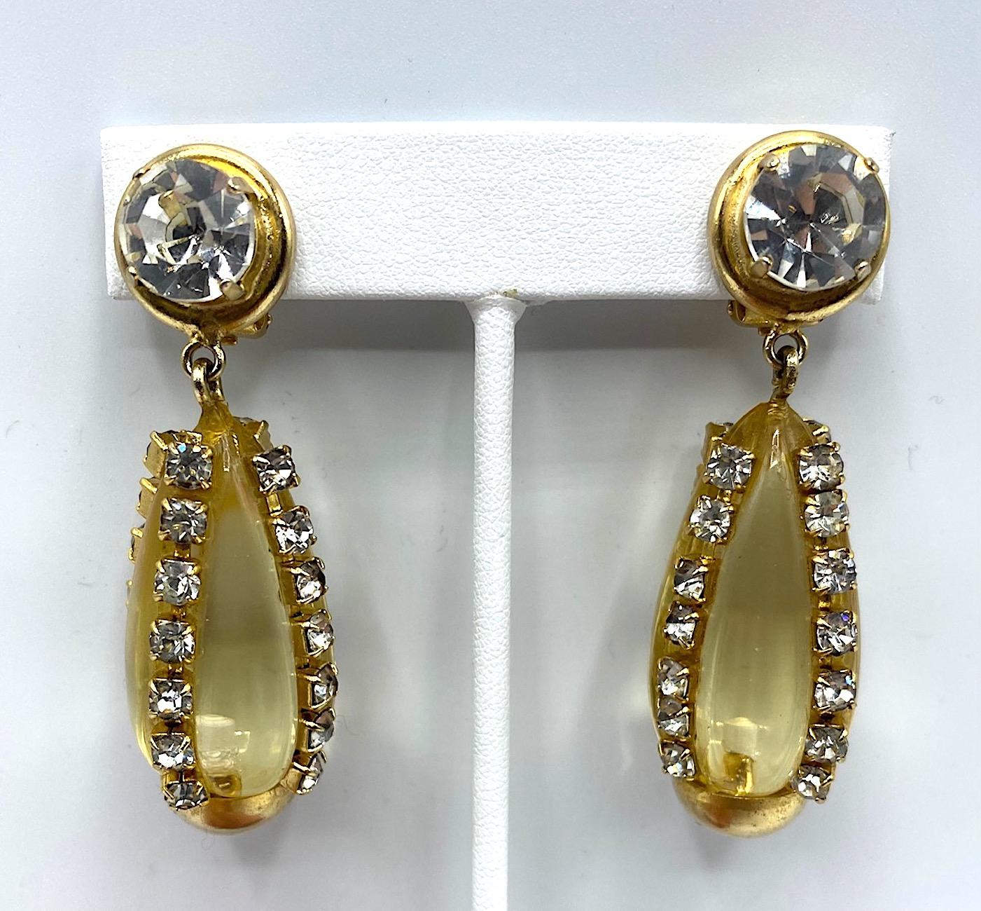 A lovely pair of Italian gold, rhinestone and lucite earrings by Italian fashion jewelry house Sharra Pagano. Each earring is gold plate and clip back. The top pieces has a single large rhinestone mounted in a round button setting .5 of an inch in