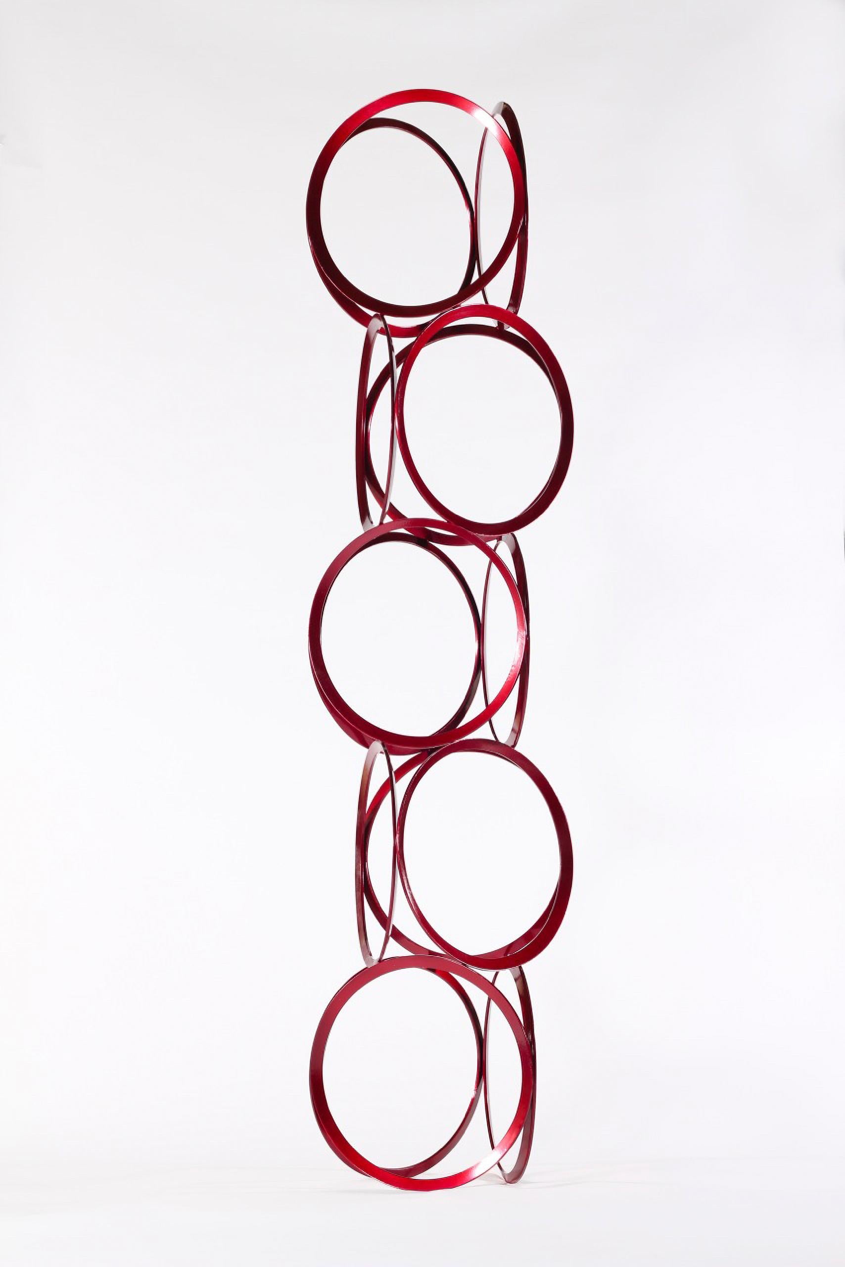Schlanke Ringe aus abgeflachtem, bonbonrotem Stahl werden vom Bildhauermeister Shayne Dark zu einer eleganten und zugleich verspielten Säule gestapelt. Das Werk mit dem treffenden Titel Drawing in Space (Zeichnung im Raum) erscheint aus