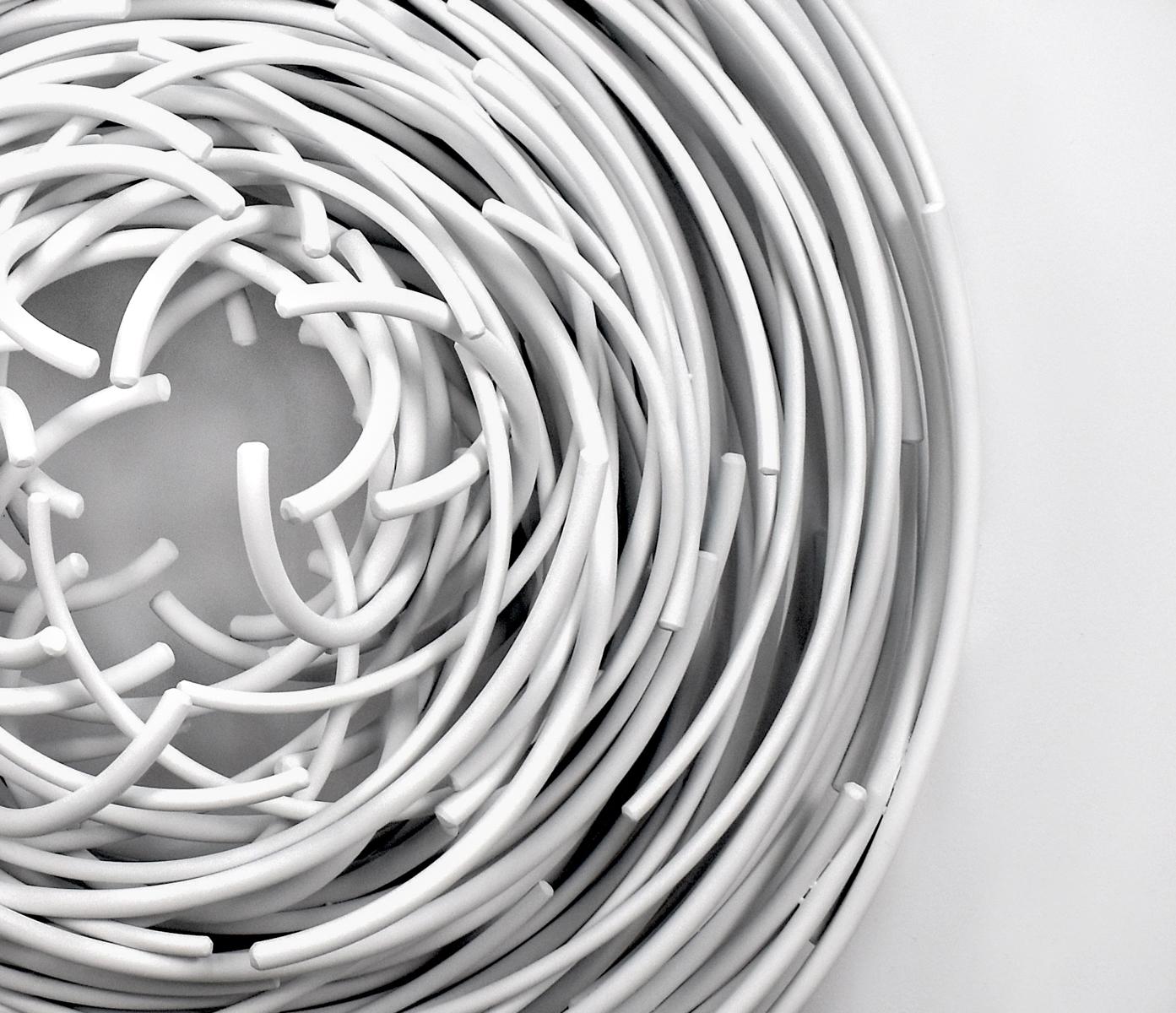 Beautiful chaos—The new sculptural series by Shayne Dark is named after the powerful image of a maelstrom—a whirlpool in a sea or river. Hand forged from round aluminum rods and painted a bright white; each rod appears to be woven into a circular