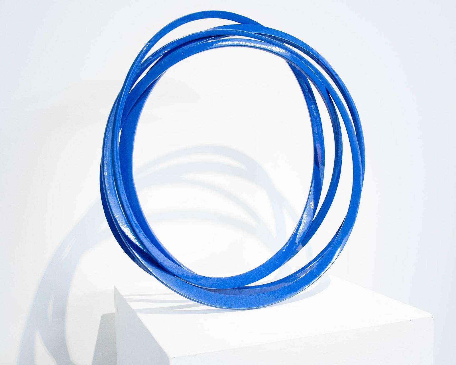 Elegant circular blue steel sculpture. The elements suggest movement and vibration, It also looks as if it might roll, spin, wobble or topple at any moment but, of course, it does not. This work is one of several composed of circles and recently