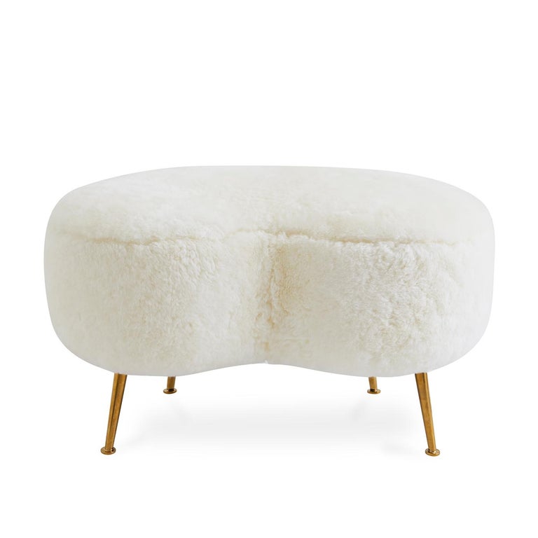 Curve Appeal. An elegant, fluid shape to give any room a swish of chic. The classic kidney-shaped silhouette gets an ultra-luxe makeover in shearling atop twinkly, angled brass legs. A curvaceous complement to any lounge chair or