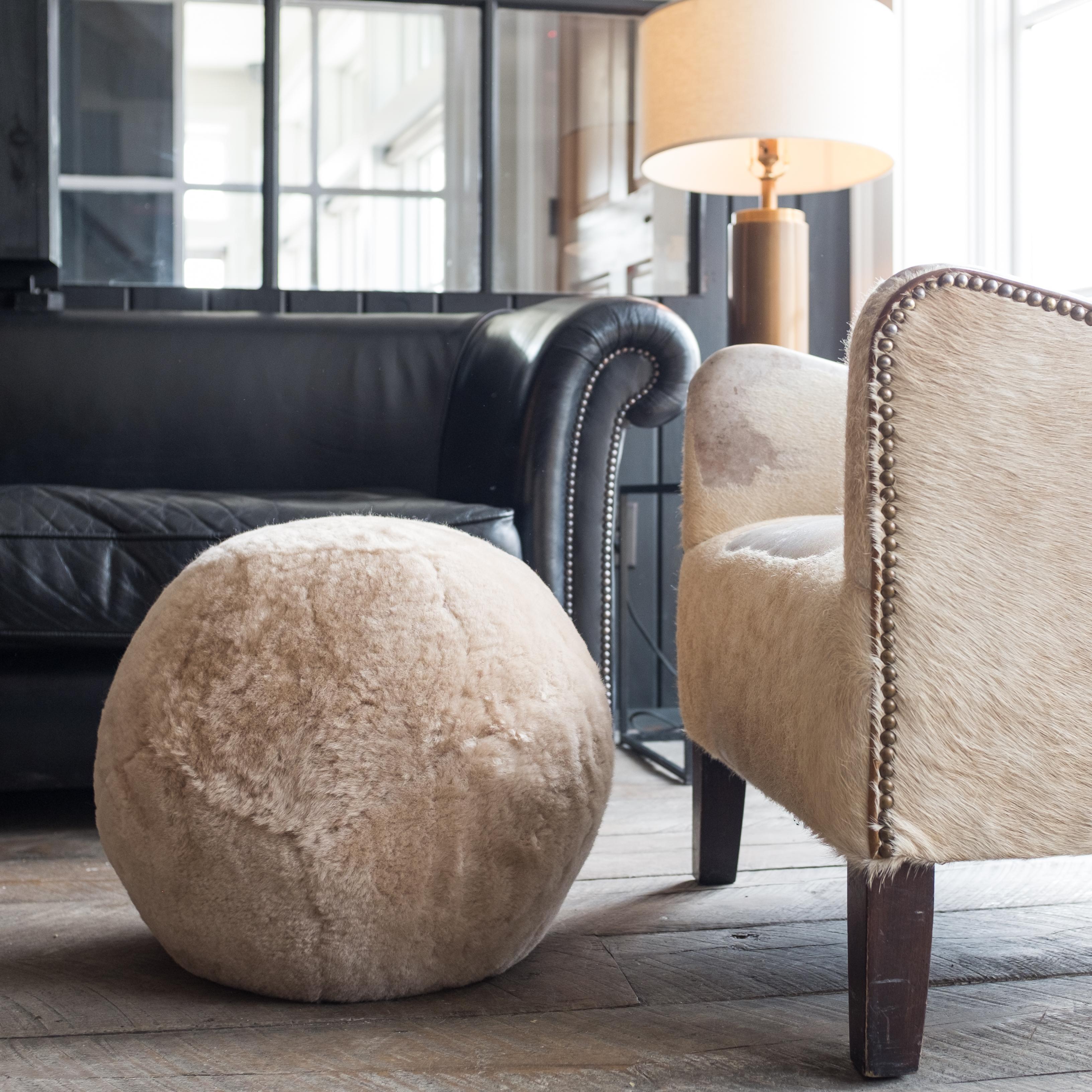 Featured with Camel color sheepskin, the Ottoman X is inspired by fundamental geometry. These structured and supportive round ball ottomans are designed to function as a traditional leg rest, add a twist to secondary living room seating, or as