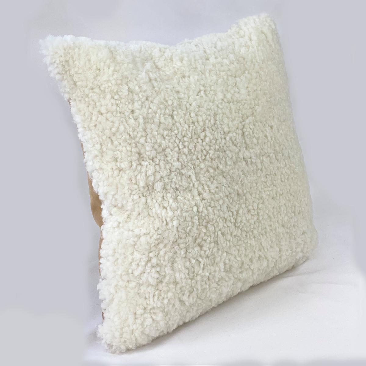 Verleihen Sie Ihrem Interieur einen erfrischenden Touch mit diesem weißen Shearling-Schafsfell-Kissen. Die Schafwolle hat einen lockigen, kurzen Wollflor, der dem Raum eine einladende und charmante Struktur verleiht. Dieses Shearling-Kissen aus der