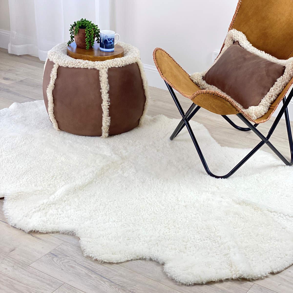 Bringen Sie mit diesem Schafsfellteppich aus reiner Wolle charmante Texturen in Ihre Einrichtung. Die Boucle-Wolle ist ein kurzes, gekräuseltes Schafsfell, das jeden Innenraumboden zum Leben erweckt. Der 100x200cm große Bodenteppich verbindet