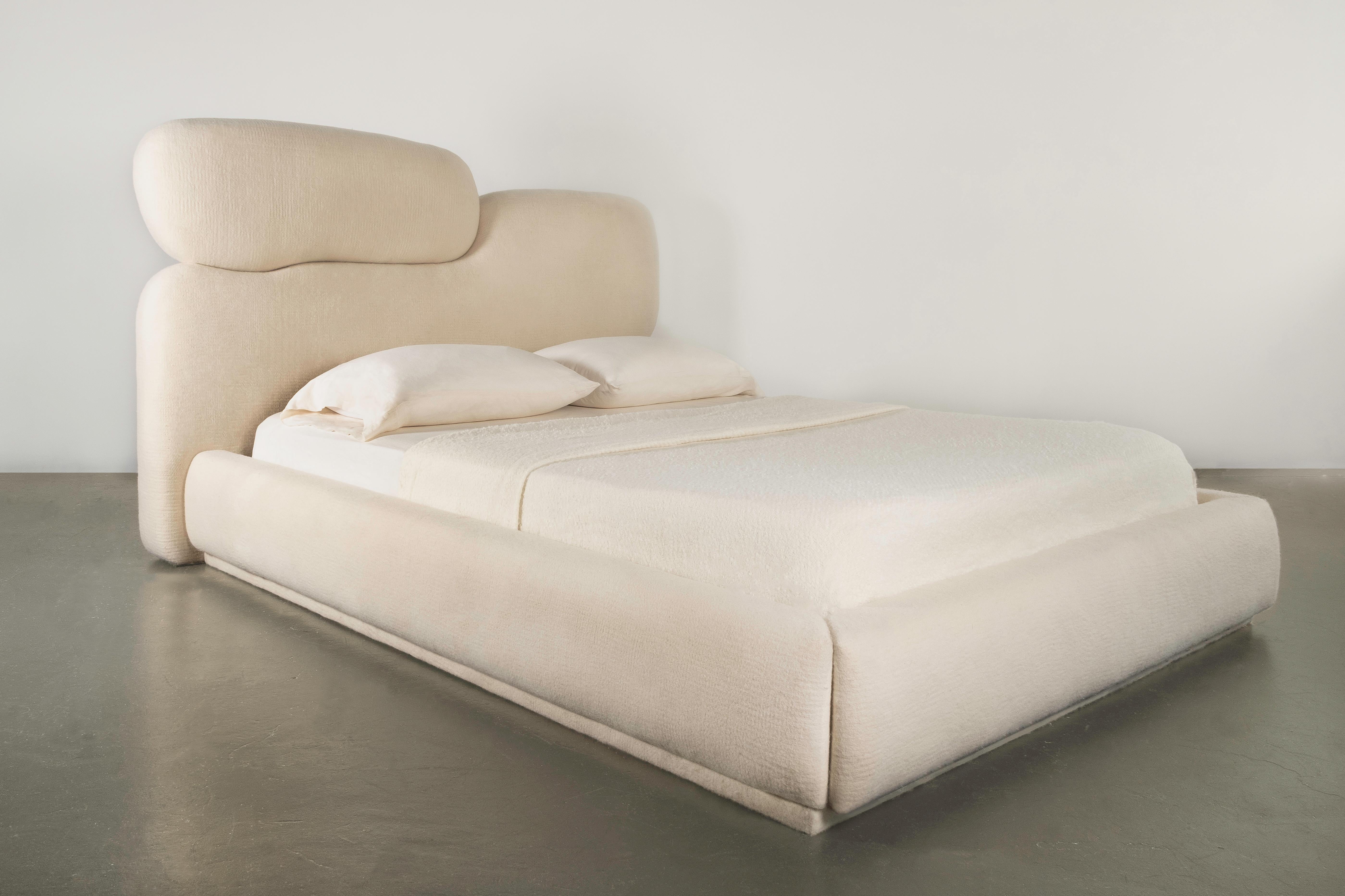 Sheep Bed designed by Studio Ahead. 

It is upholstered in custom cream merino wool felt from Northern California sheep. 

The shape of the headboard is inspired by the smooth lines of stones found on Muir Beach that has been washed by a current