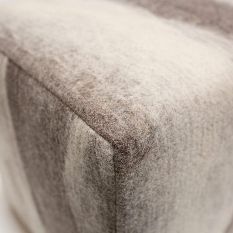 Felted wool fabric made in our workshop, each one one-of-a-kind from our painterly felted wool over a finely upholstered ottoman with wood legs.

The ottoman is manufactured in Portland, Oregon USA by an accomplished fine furniture builder for