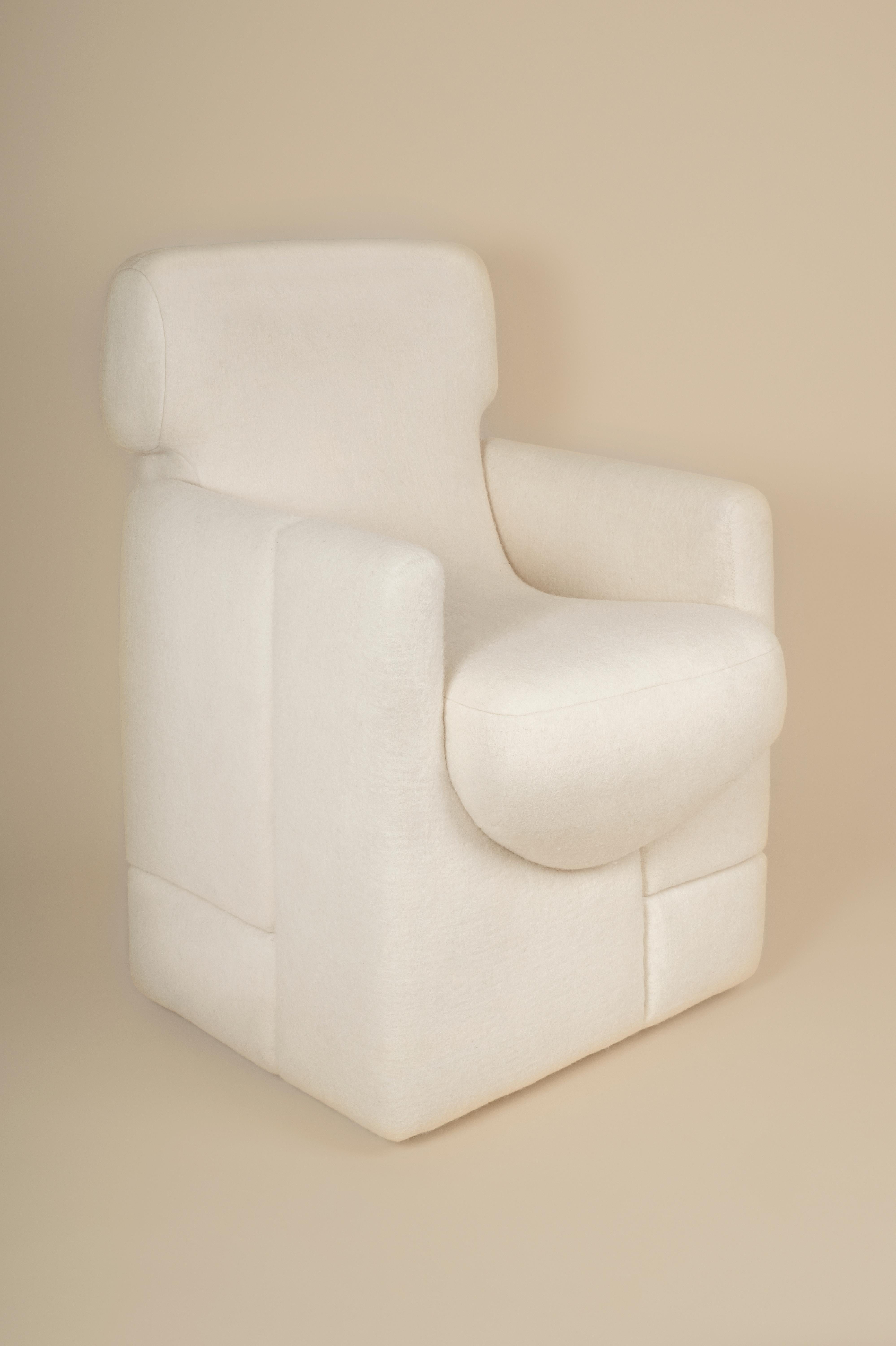 Chaise de salle à manger Sheep conçue par Studio Ahead. La chaise est tapissée d'un feutre de laine mérinos crème personnalisé provenant de moutons de Californie du Nord. Les formes de la chaise s'inspirent de la courbure des pierres trouvées à Muir