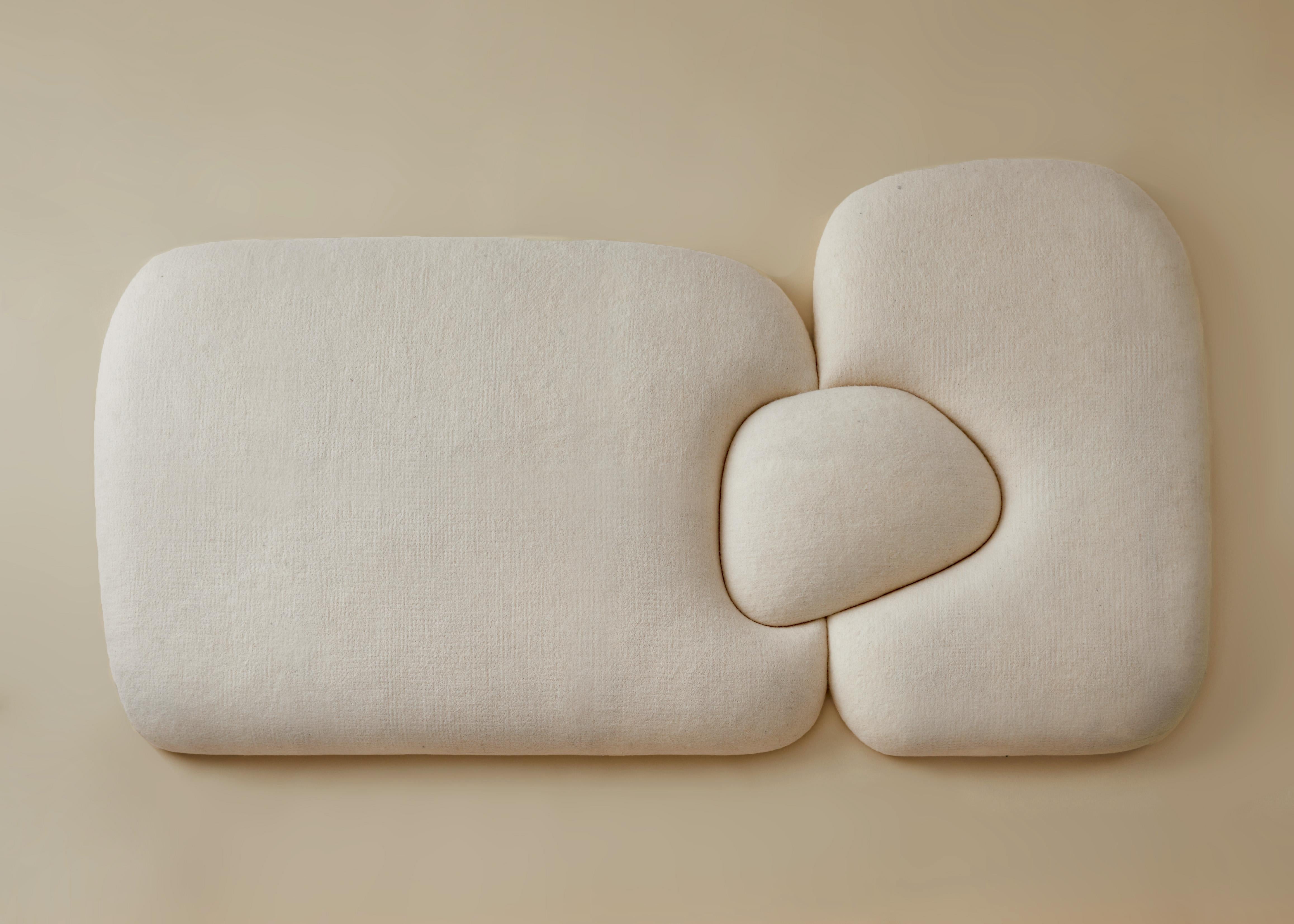 Tête de lit en forme de mouton conçue par Studio Ahead. Cet objet sculptural bouffant et doux pourrait être utilisé comme tête de lit ou comme œuvre d'art indépendante. 

Il est recouvert de feutre de laine mérinos crème provenant de moutons de