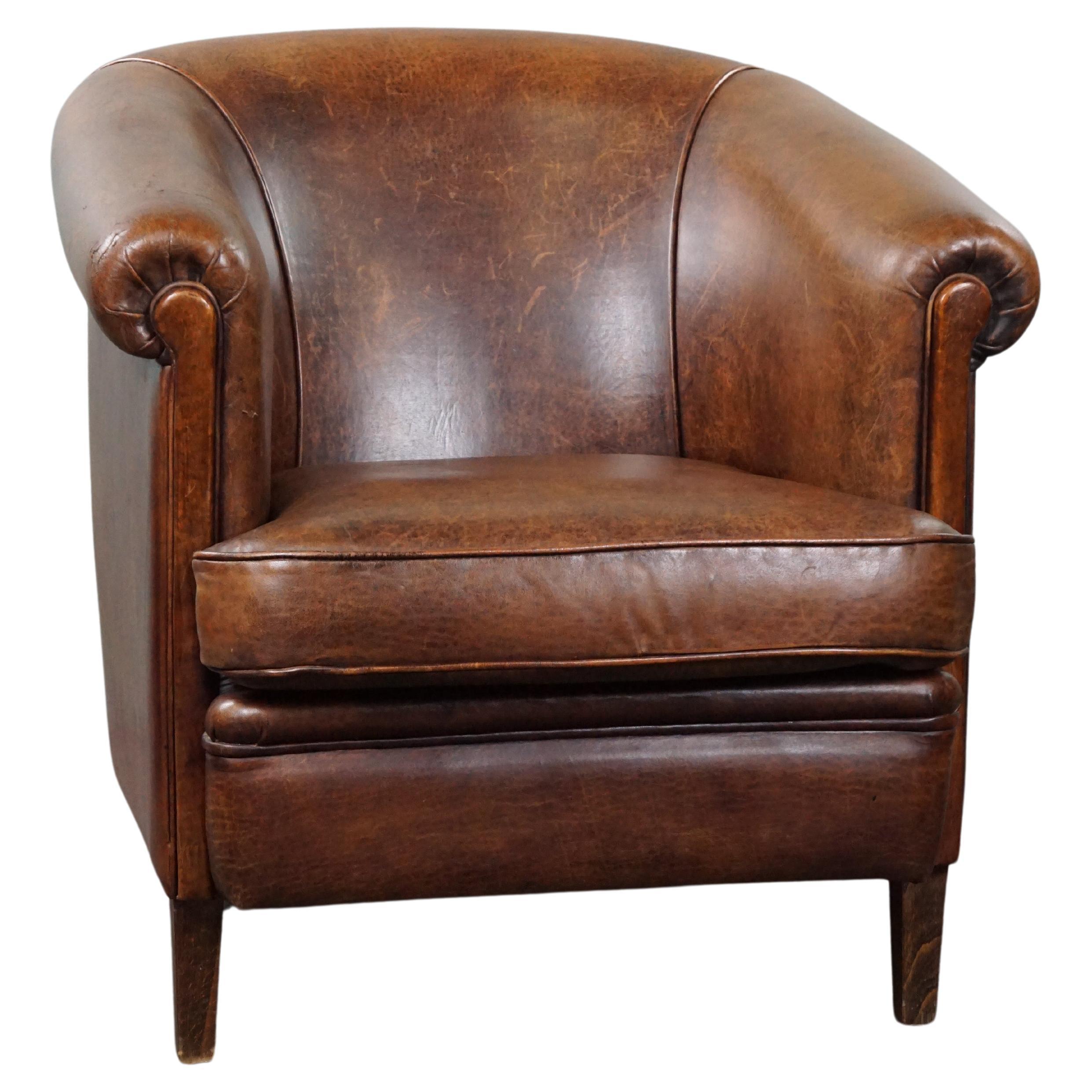 Sheep leather club armchair with a beautiful patina and a tone-on-tone piping For Sale