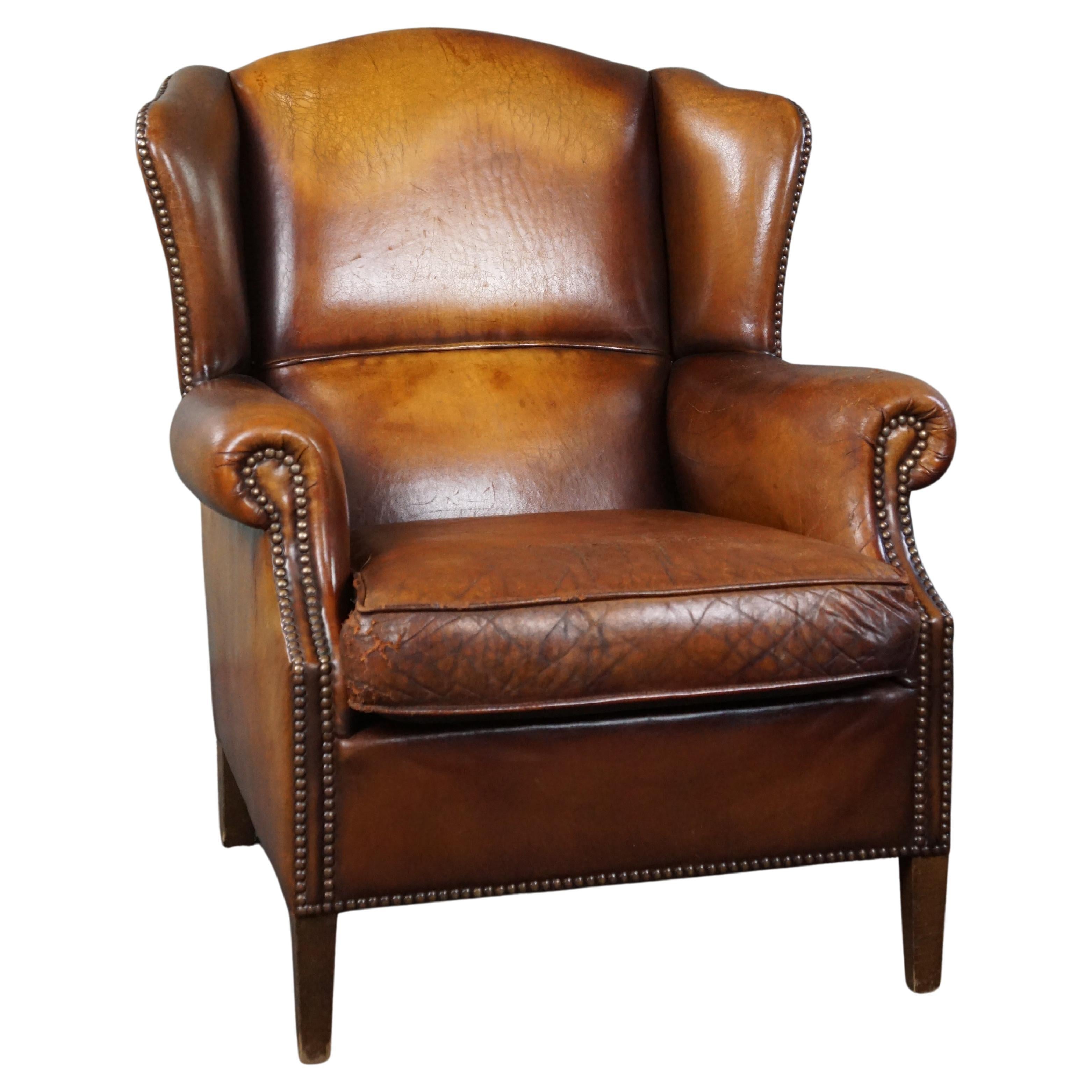 Sheep leather wingback chair with a beautiful patina For Sale