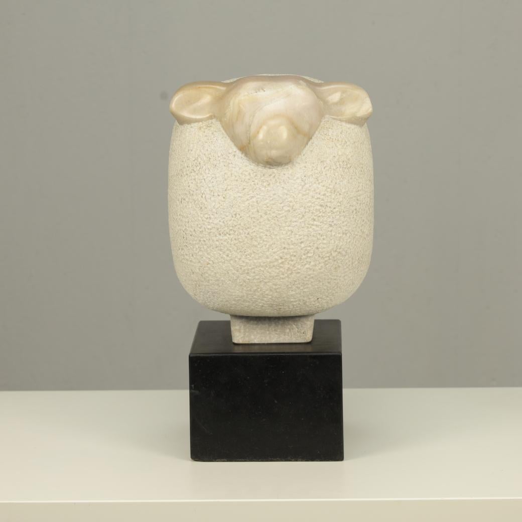 H 42 x W 24 x D 34 cm  Weight: 42 kg  Very good condition
Material: Portuguese marble, black stone base

At once tender and sculptural, this marble sheep by Fanny Baan (1995) is a study in contrast and simplicity. The head, smoothly polished, rests