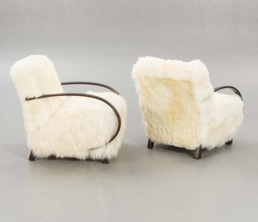 Beautiful period 1950s armchairs upholstered in Scandinavian sheepskin. Very minor wear and stunning in its shape and proportions.