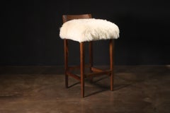 Tabouret contemporain à dossier bas en peau de mouton et bois exotique de Costantini, Umberto