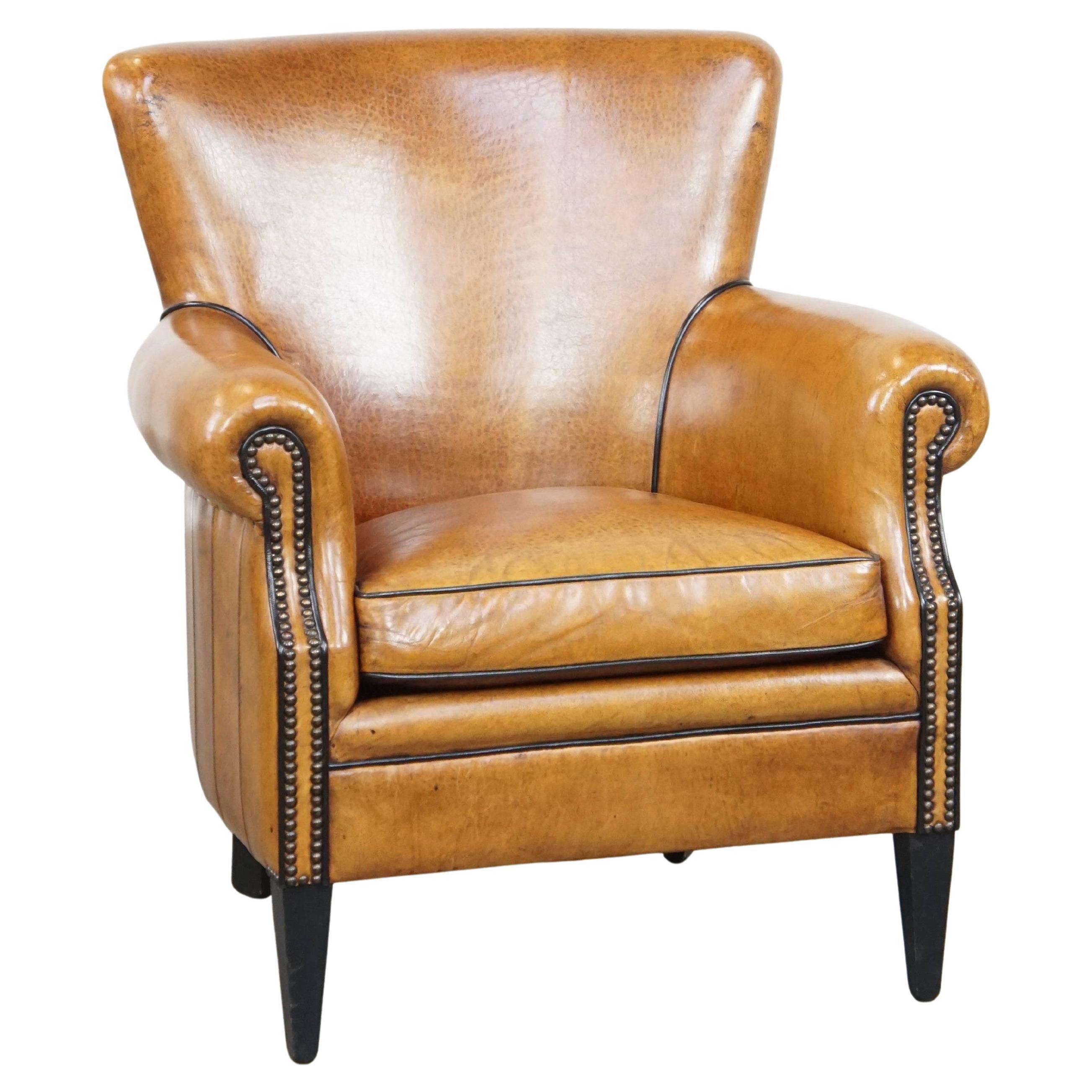 Sheepskin armchair in a light cognac color, finished with decorative nails