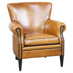 Sheepskin armchair in a light cognac color, finished with decorative nails