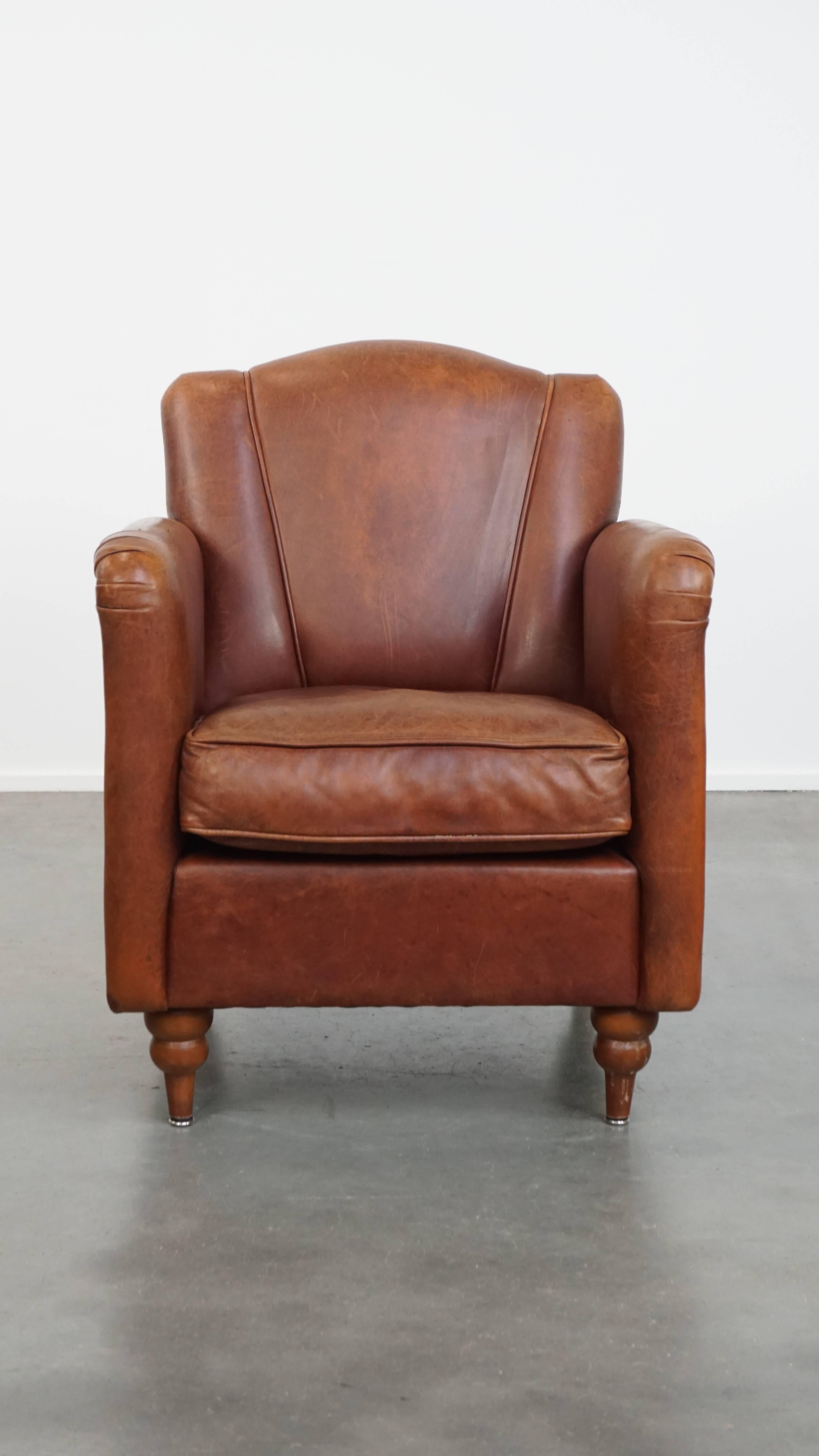 In offerta c'è questa elegante poltrona Art Deco in pelle di pecora dal design e dal carattere senza tempo. 

Questa poltrona, realizzata in pelle di pecora e rifinita con le classiche borchie decorative, presenta un design Art Déco elegante e senza