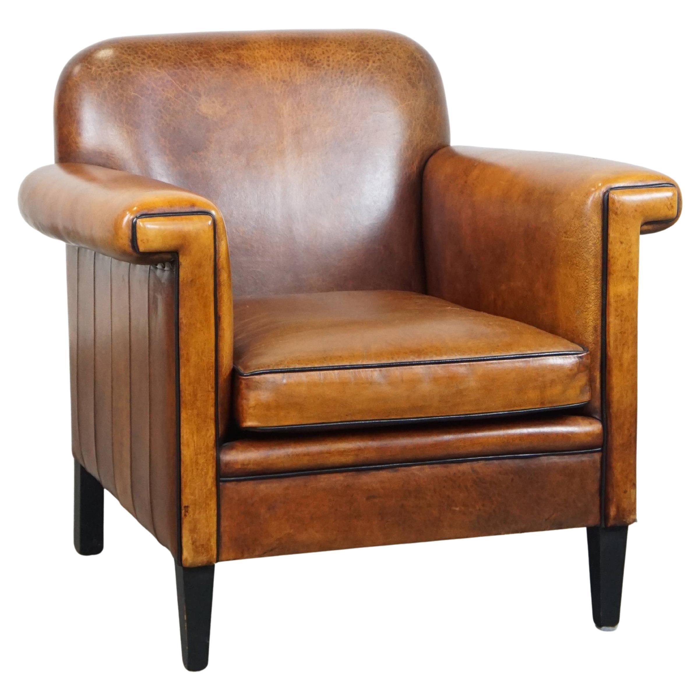 Sheepskin Art Deco design armchair in good condition, finished with black piping