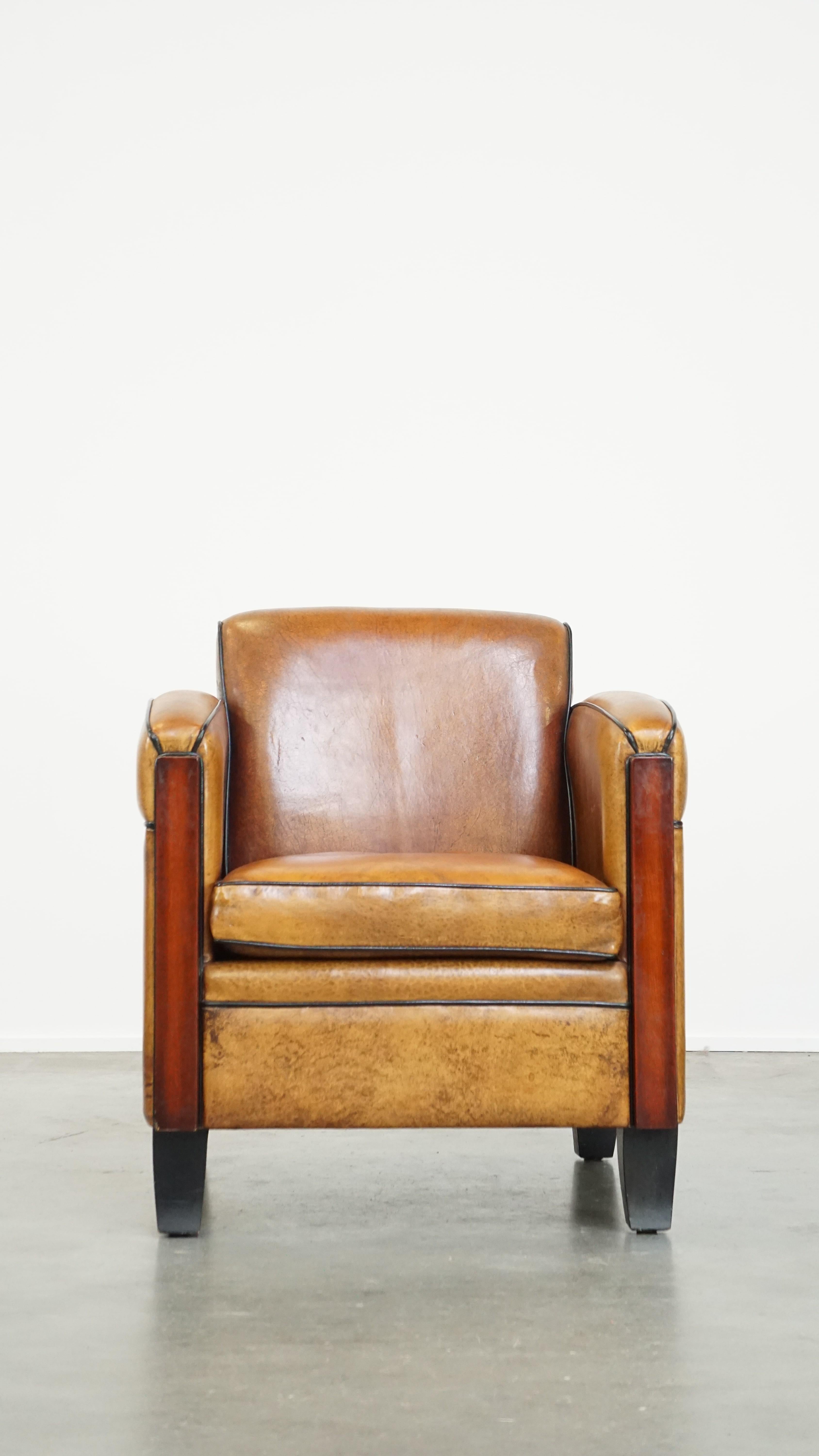 This unique and comfortable sheepskin Art Deco armchair is finished with stunning wooden accents. It fits beautifully into nearly any interior and is a true eye-catcher. It features a loose seat cushion, decorative nail detailing on the back, and