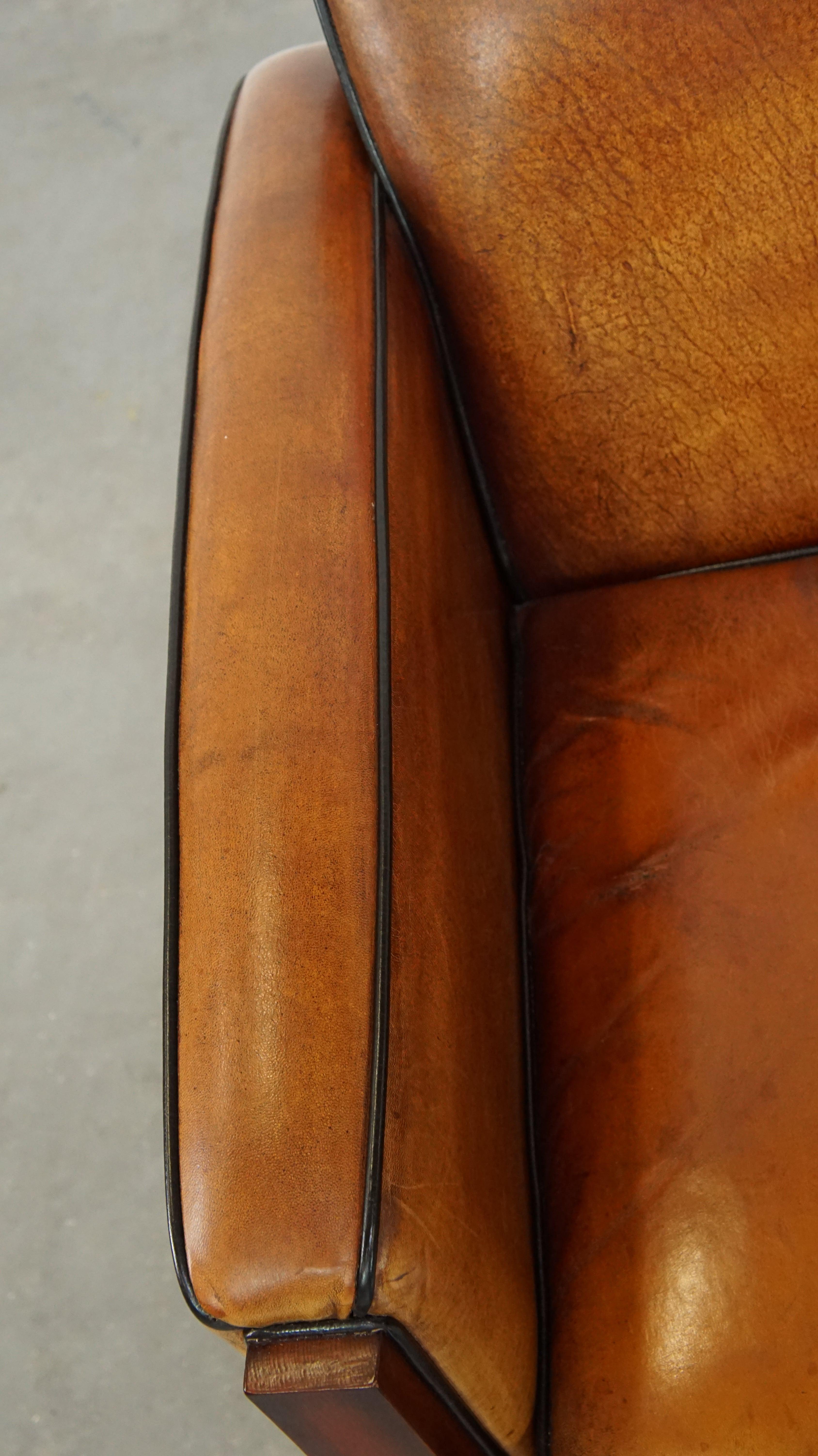Sheepskin Art Deco design armchair with gorgeous wooden details and black piping For Sale 2