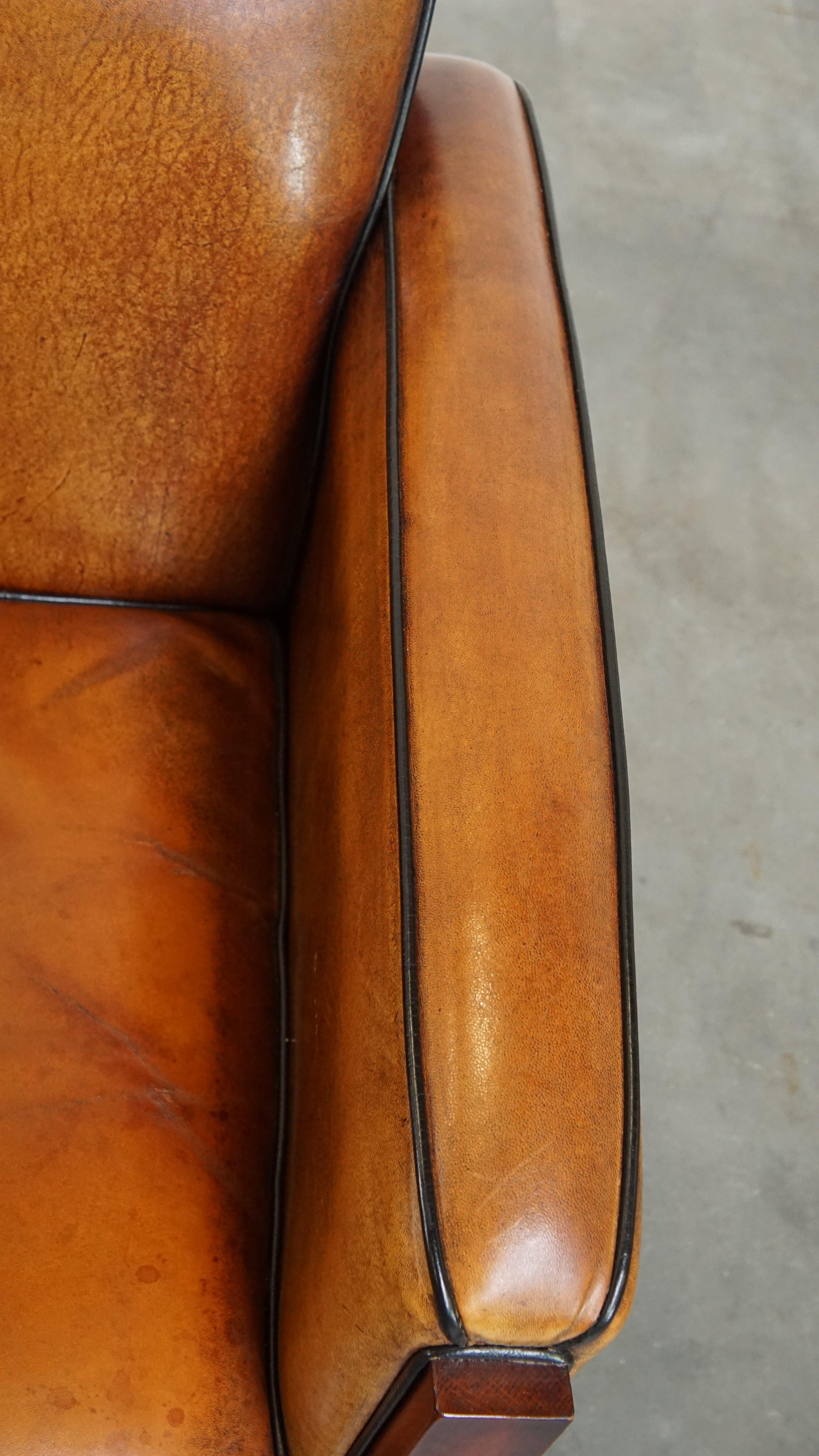 Sheepskin Art Deco design armchair with gorgeous wooden details and black piping For Sale 3