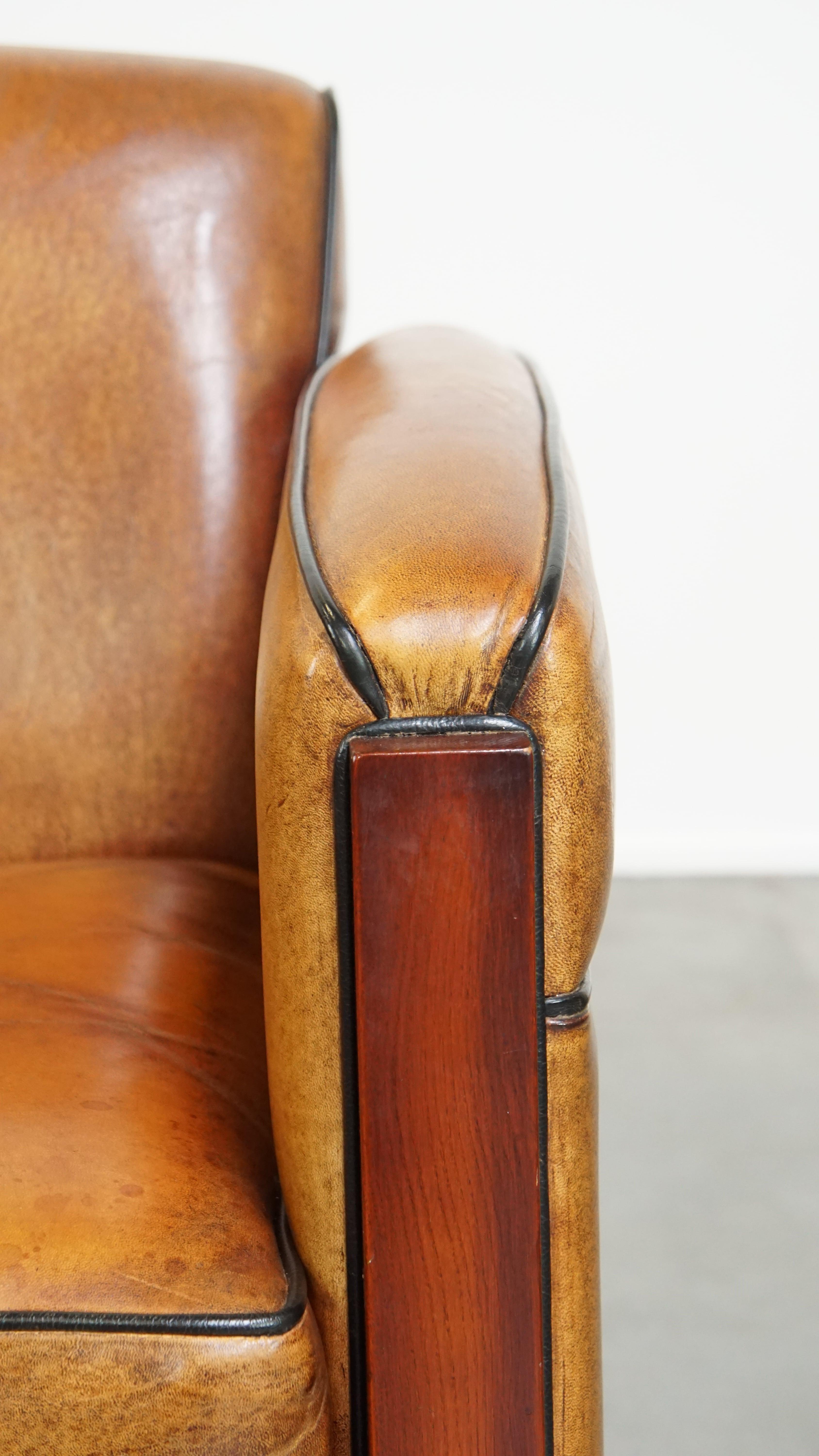 Sheepskin Art Deco design armchair with gorgeous wooden details and black piping For Sale 4