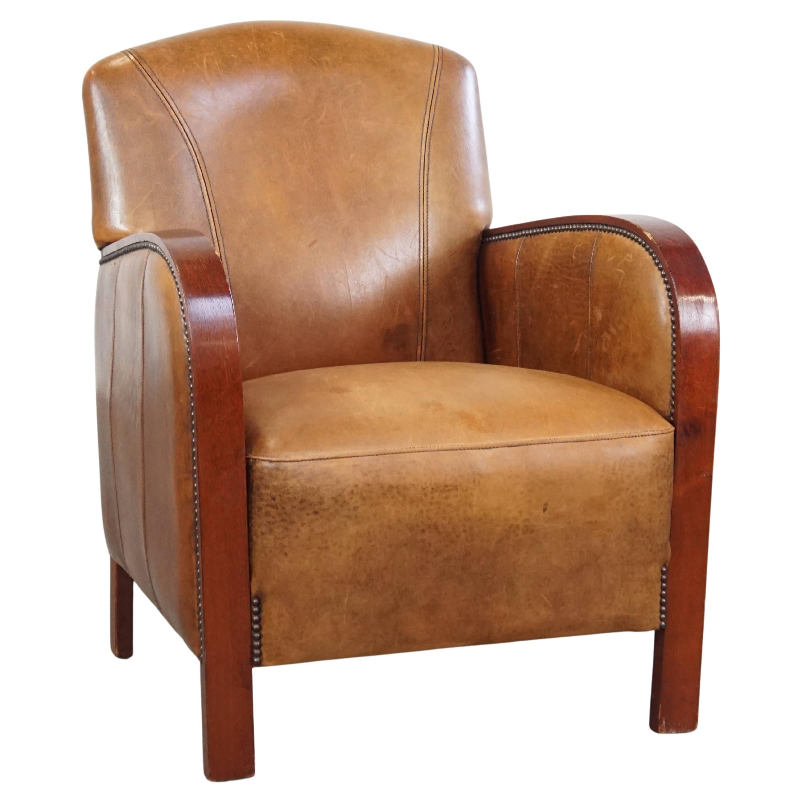 Sheepskin Art Deco design armchair with wooden armrests and a fixed seat cushion