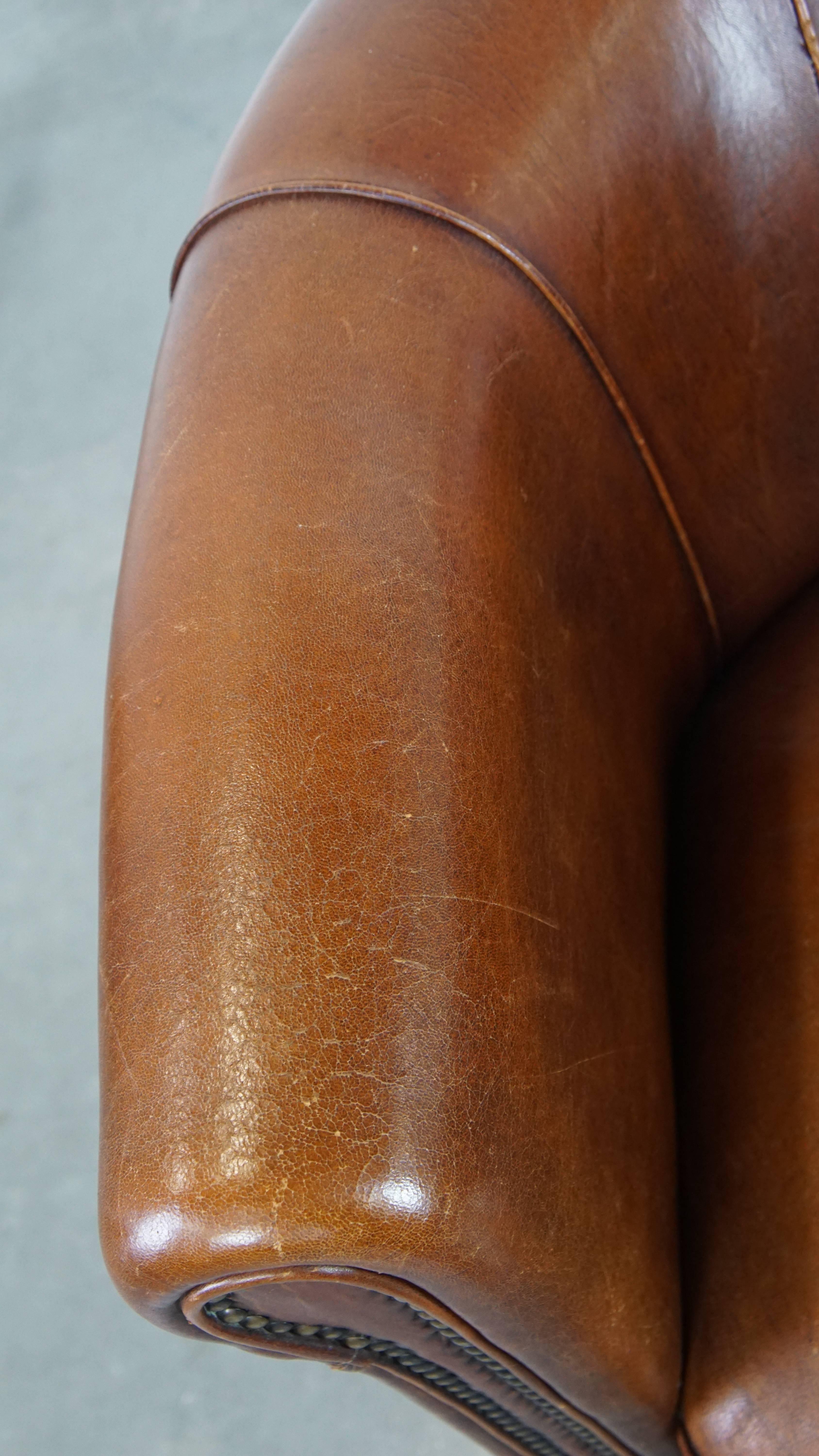 Sillón club de piel de oveja en un encantador color coñac con ribete en el respaldo en venta 1