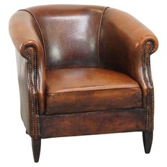 Fauteuil club en peau de mouton au look vintage, finitions décoratives