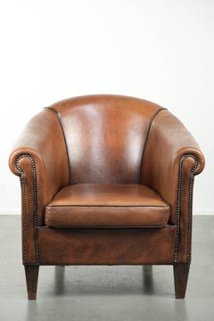 Sheepskin club armchair with beautiful patina and finish with black piping