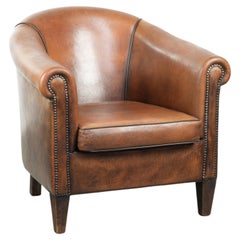 Sheepskin club armchair with beautiful patina and finish with black piping