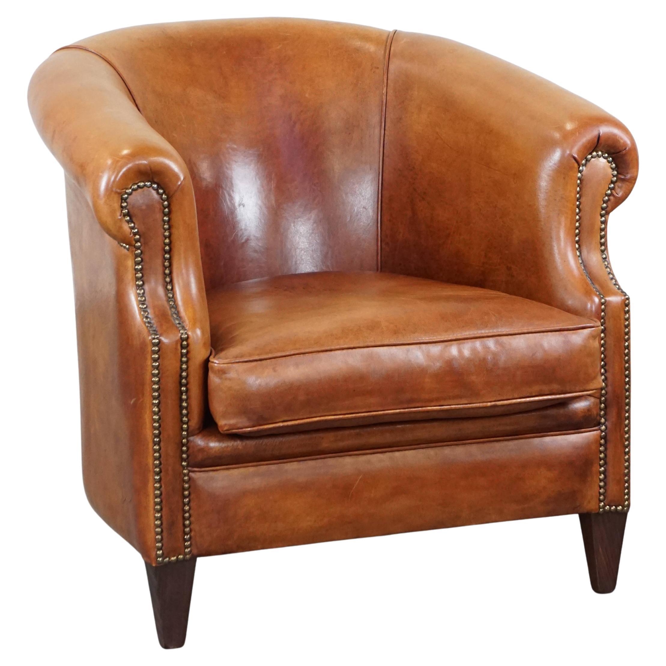 Sillón club de piel de oveja correctamente acabado con clavos decorativos en buen estado