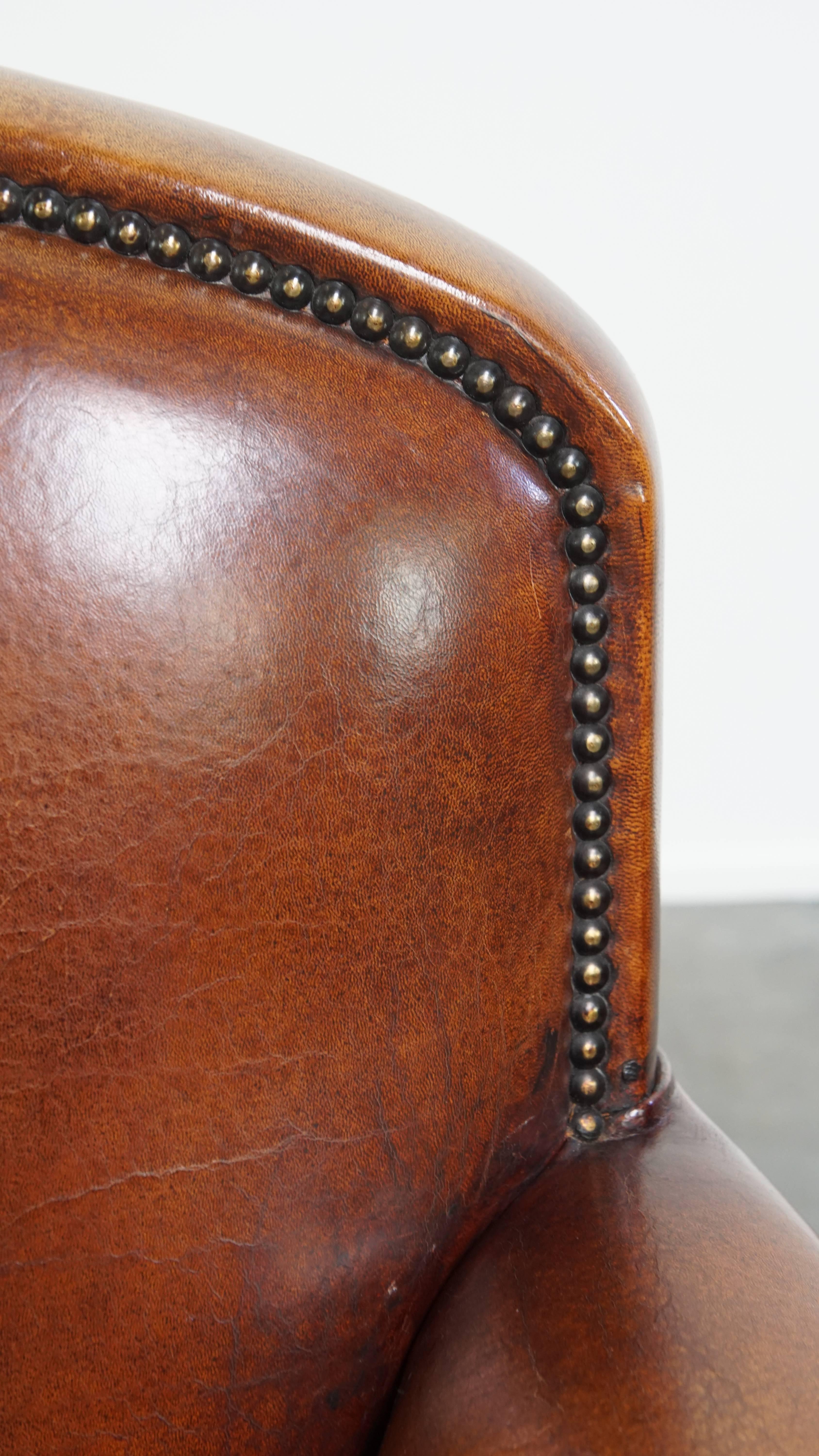 Sheepskin leather armchair in a cognac color with black piping For Sale 9