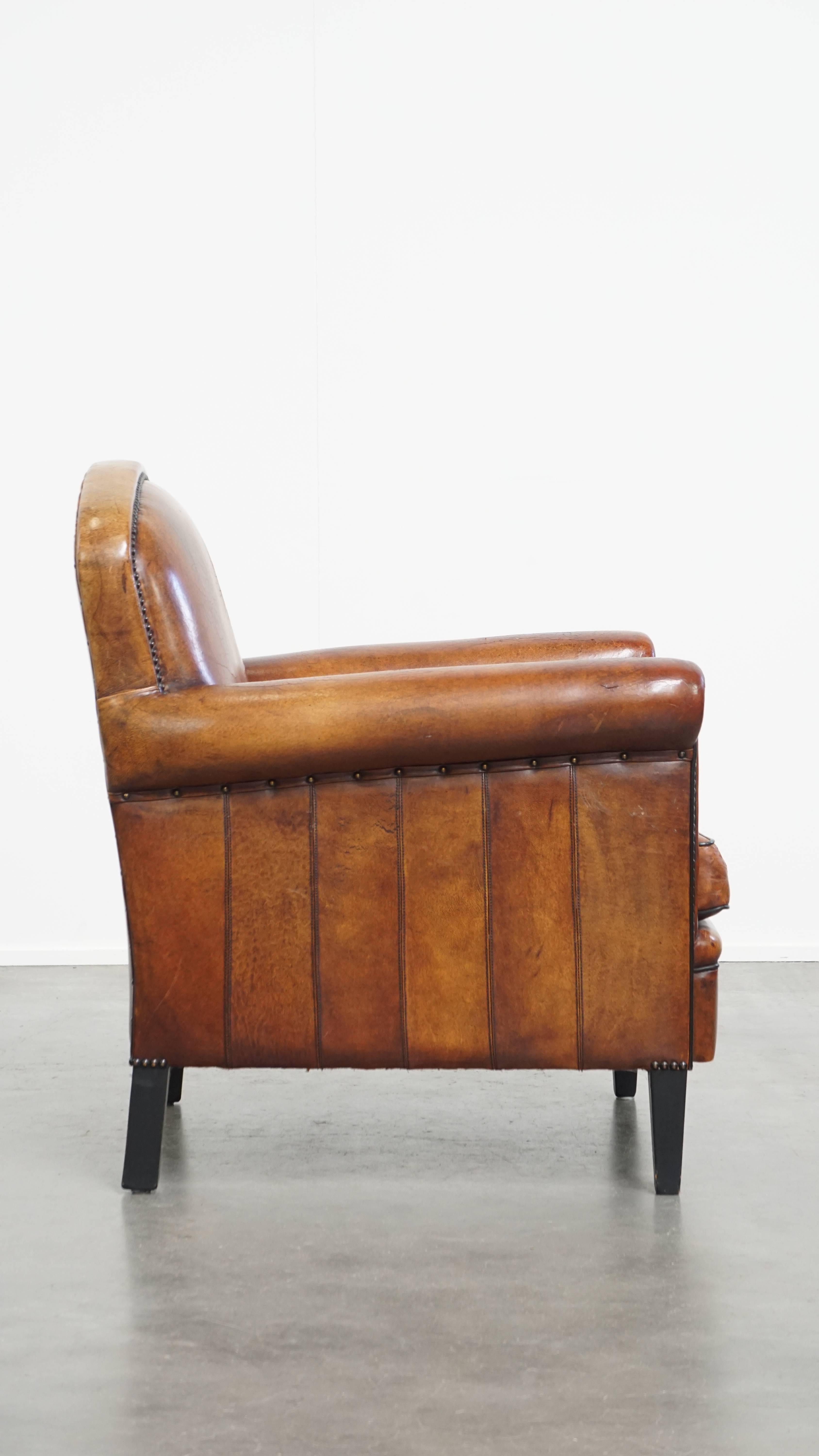 Classical Roman Sheepskin leather armchair in a cognac color with black piping For Sale