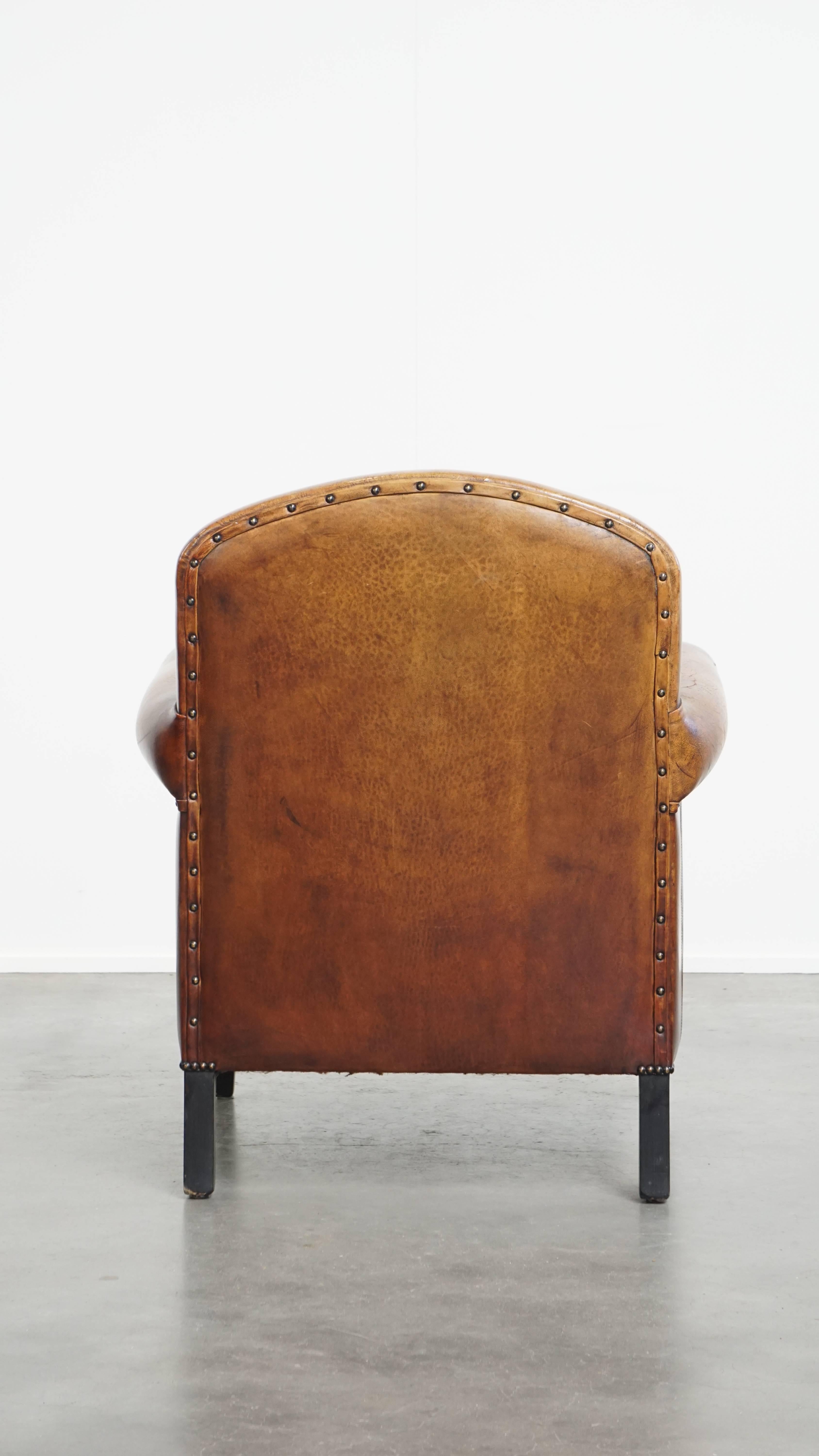 Hand-Crafted Sheepskin leather armchair in a cognac color with black piping For Sale