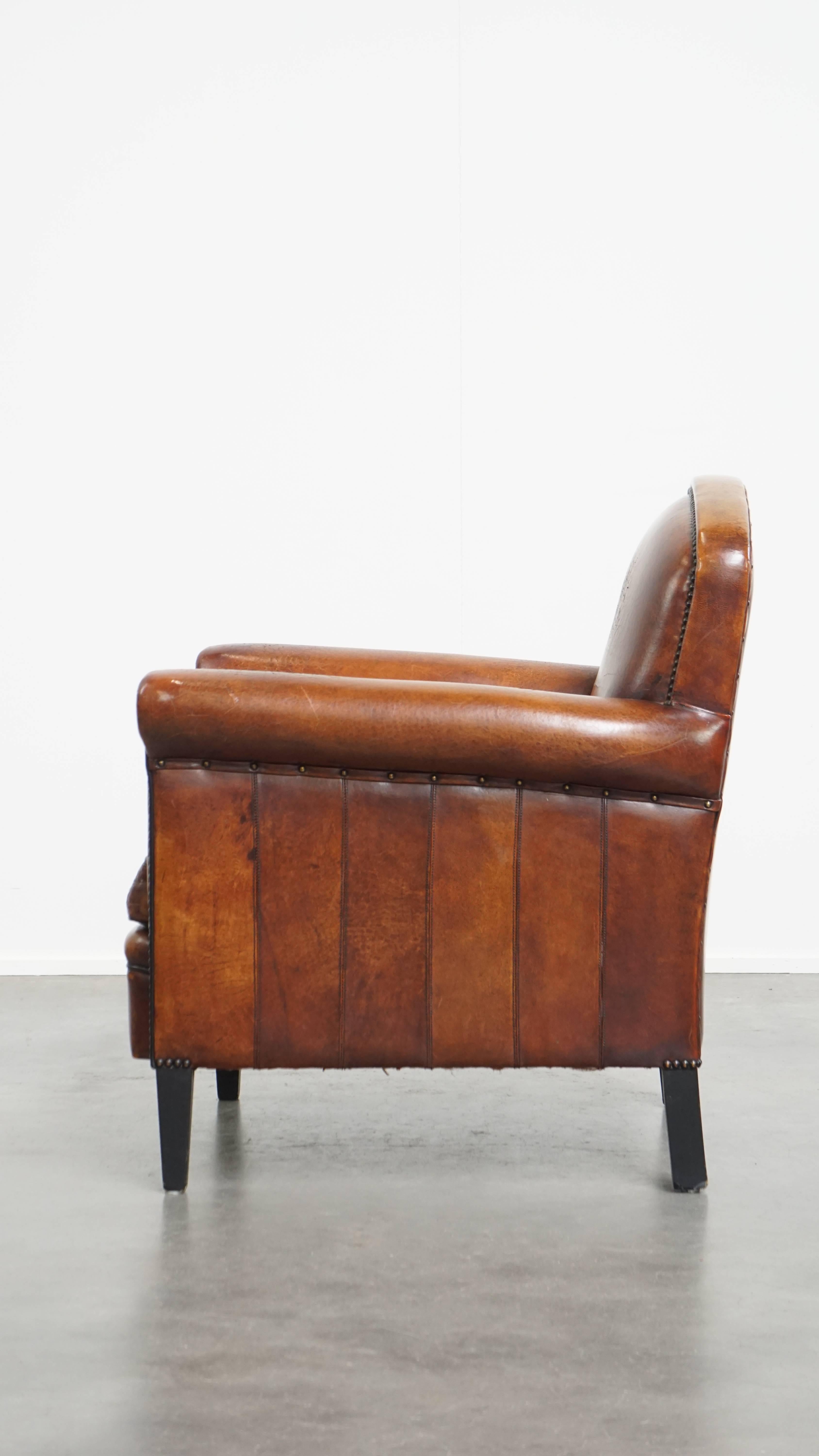 Sheepskin leather armchair in a cognac color with black piping In Good Condition For Sale In Harderwijk, NL