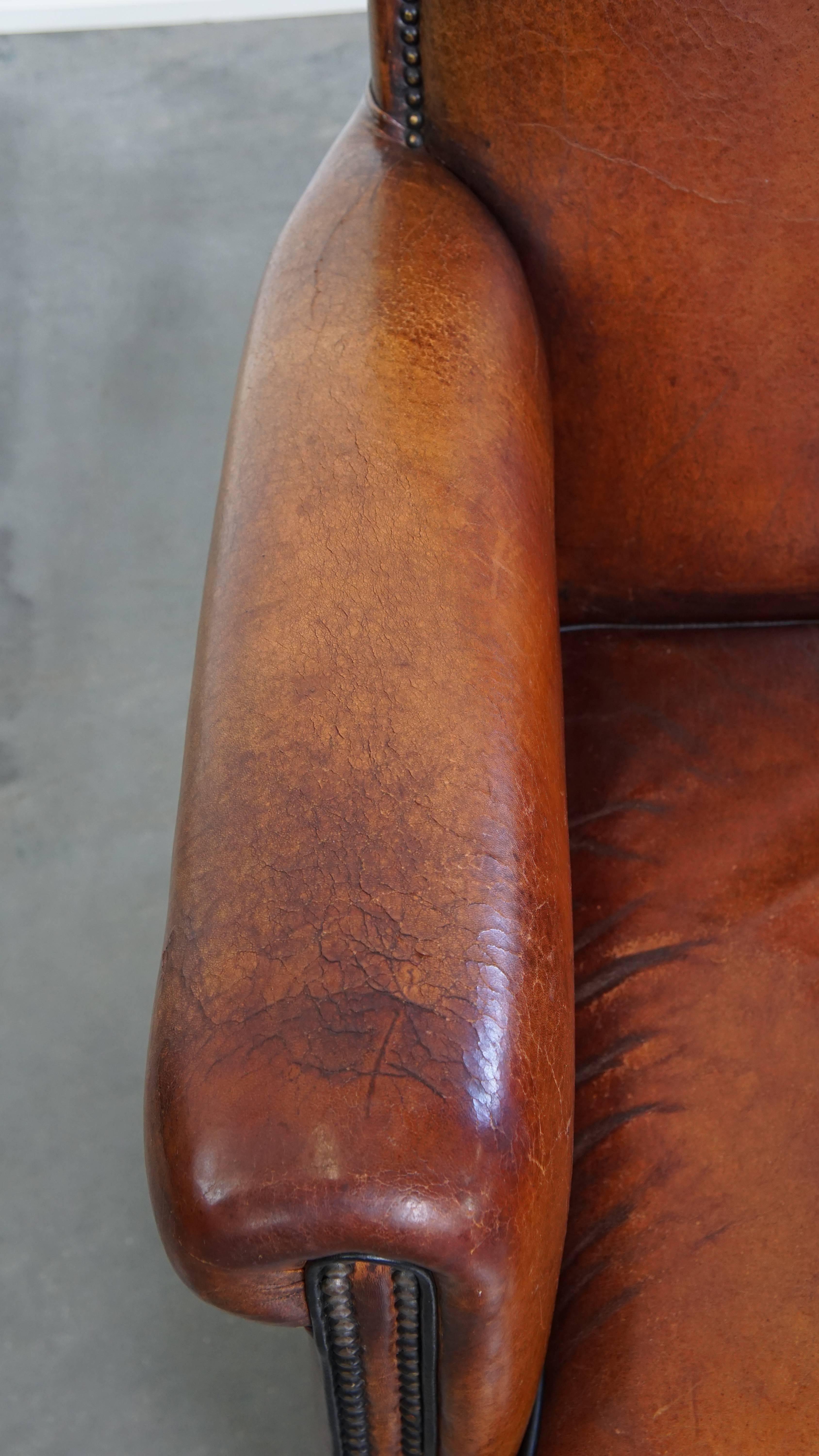 Leather Sheepskin leather armchair in a cognac color with black piping For Sale